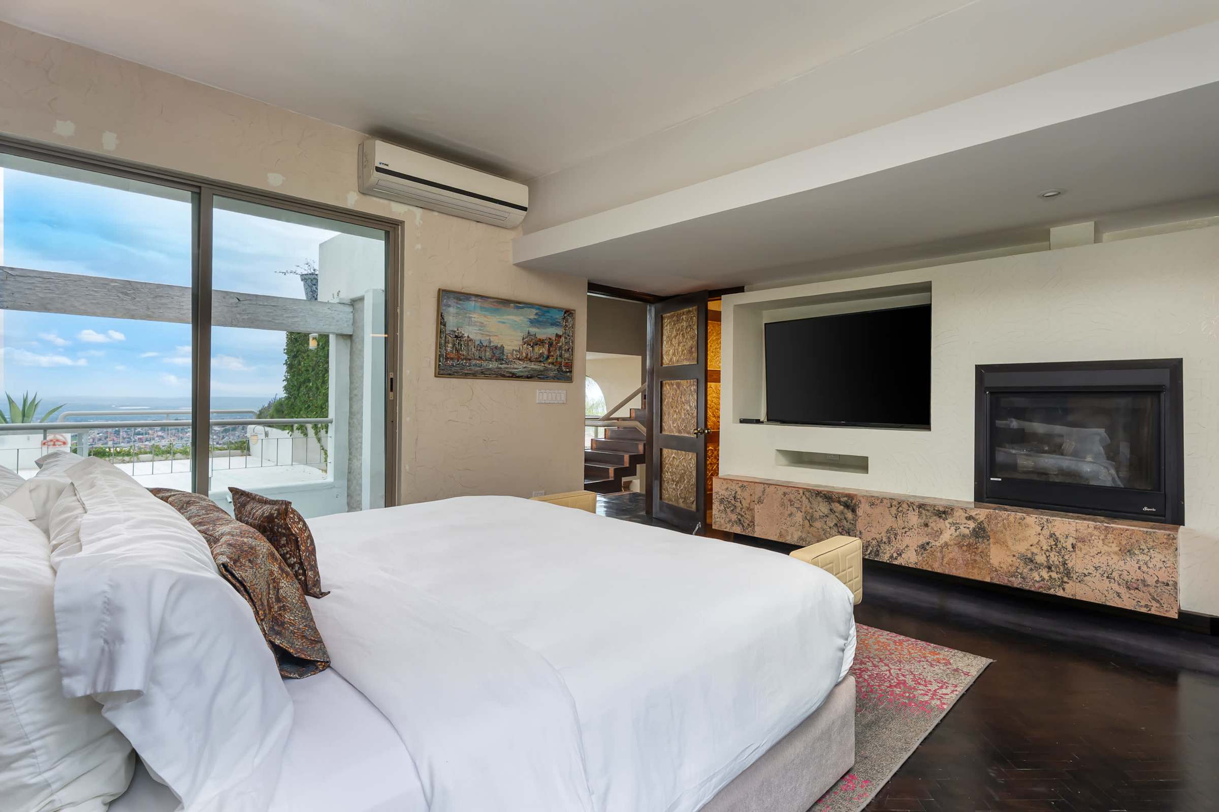 Guest suite king bed with TV, fireplace and city views