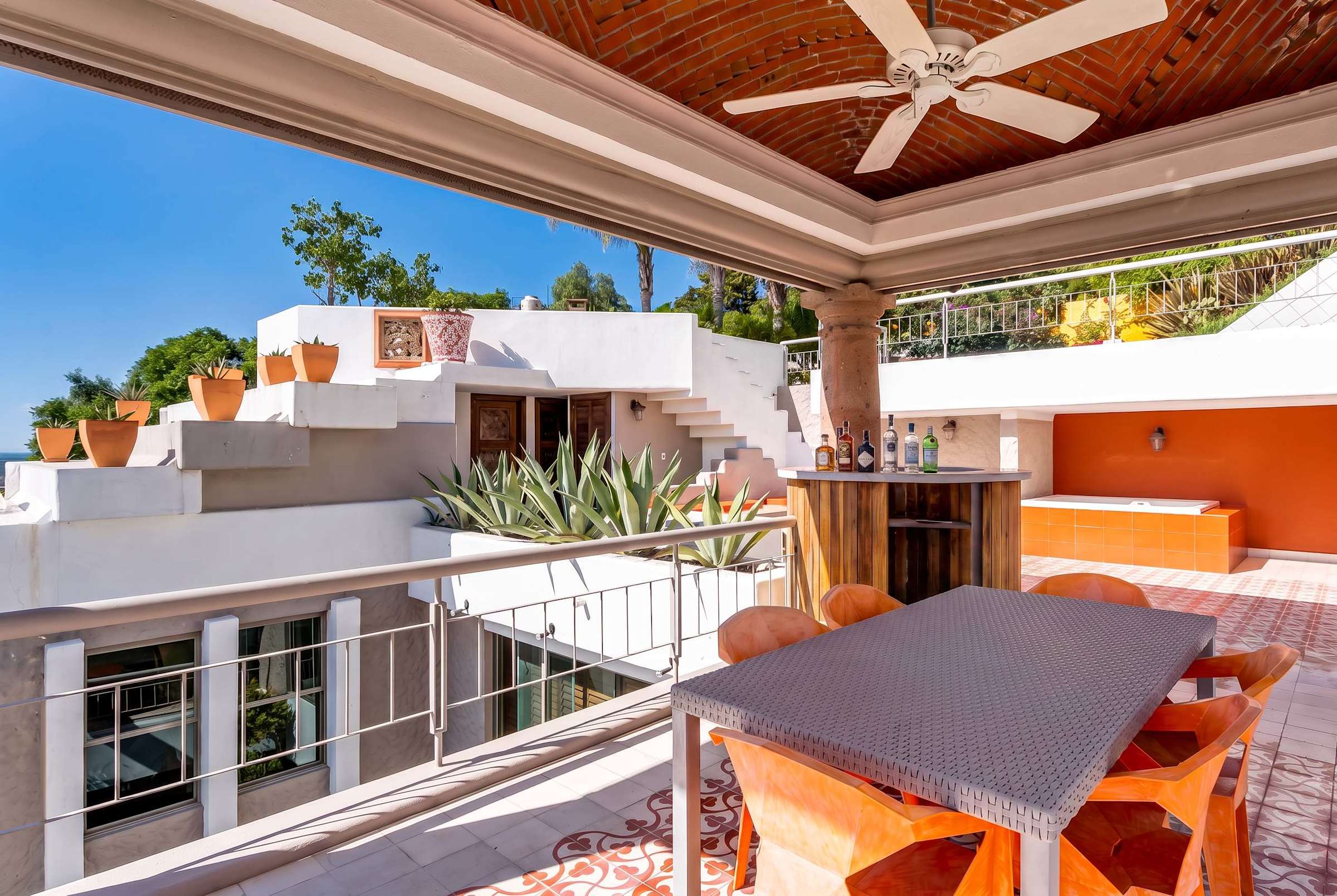 Top-level balcony terrace with hot tub, fire pit, bar and outdoor dining area