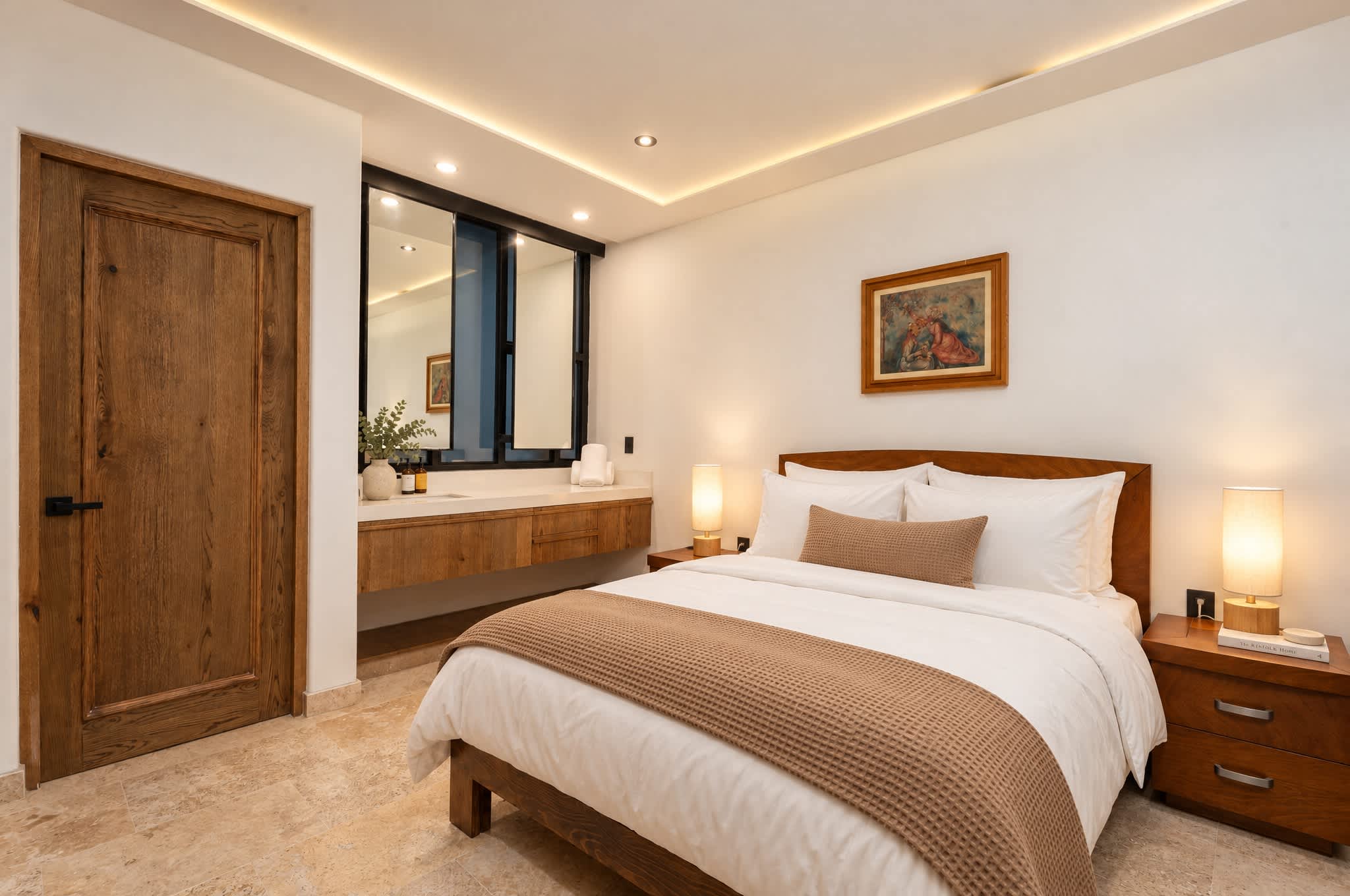 Recámara con cama queen, tocador de madera con espejo e iluminación empotrada en el techo
