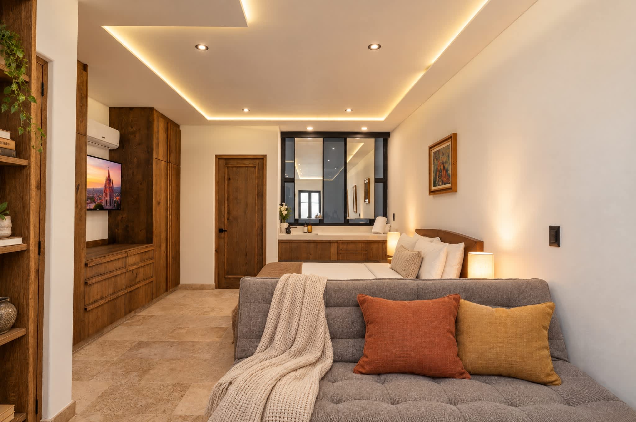 Recámara principal con sofá cama, cama queen y baño privado con acabados modernos