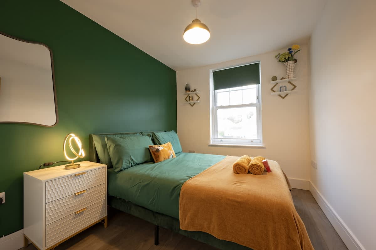 Double bedroom with green feature wall and Street view window