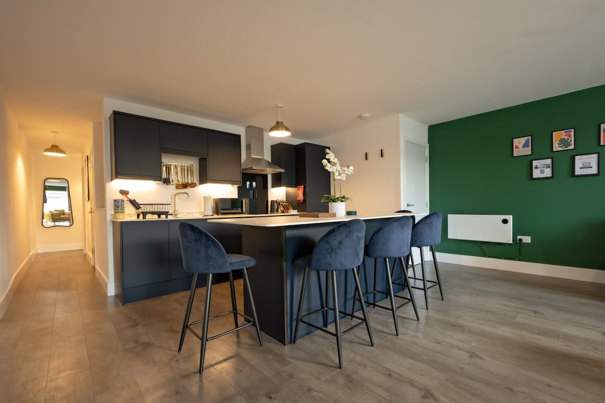 The Hideaway Cinema Retreat: Open-plan kitchen with breakfast bar seating and a green feature wall