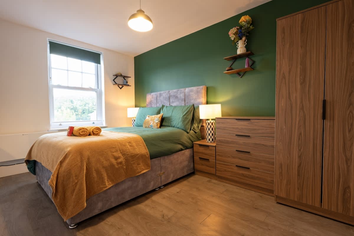 King bedroom with fitted wardrobes and warm wood tones