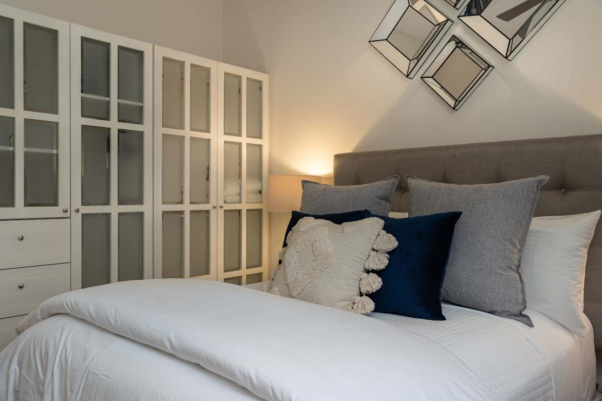 Guest bedroom with queen bed and closet