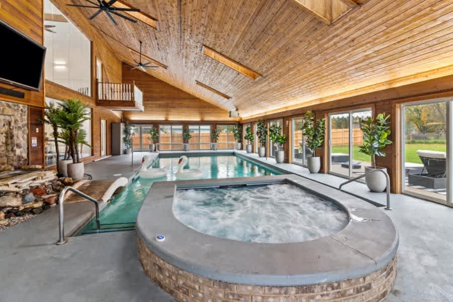 Our heated indoor pool area is an all-season retreat, complete with a nine-person hot tub and surrounded by lush greenery seen through floor-to-ceiling windows.