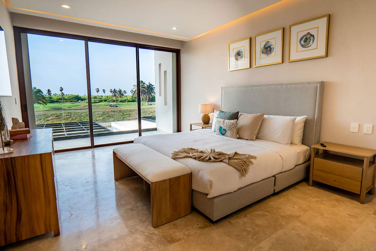 Bedroom 5 with a plush king bed, contemporary decor, and golf course views through sliding glass doors