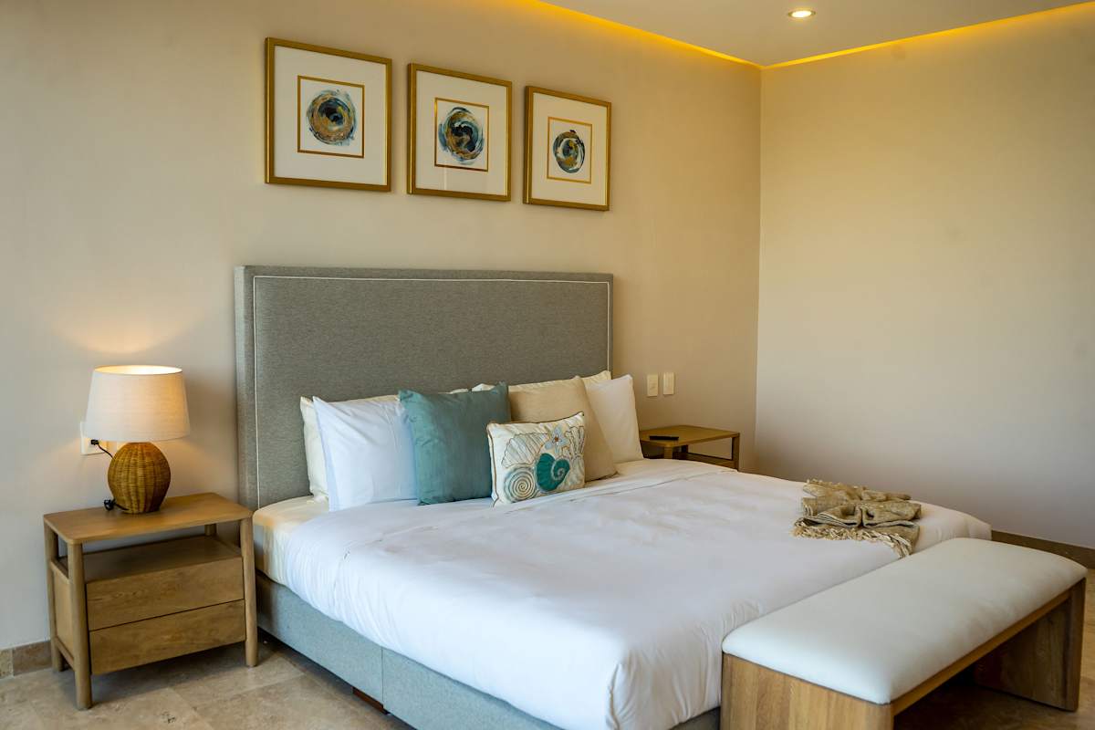 Another view of Bedroom 5 showcasing the king bed with teal accents and elegant nature-inspired artwork