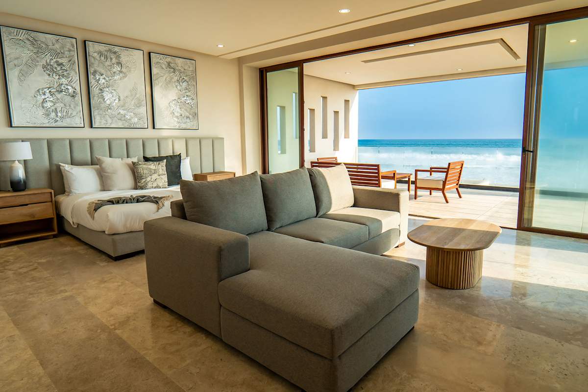 Bedroom 6 with a generous sitting area, large sectional sofa, and stunning panoramic ocean views