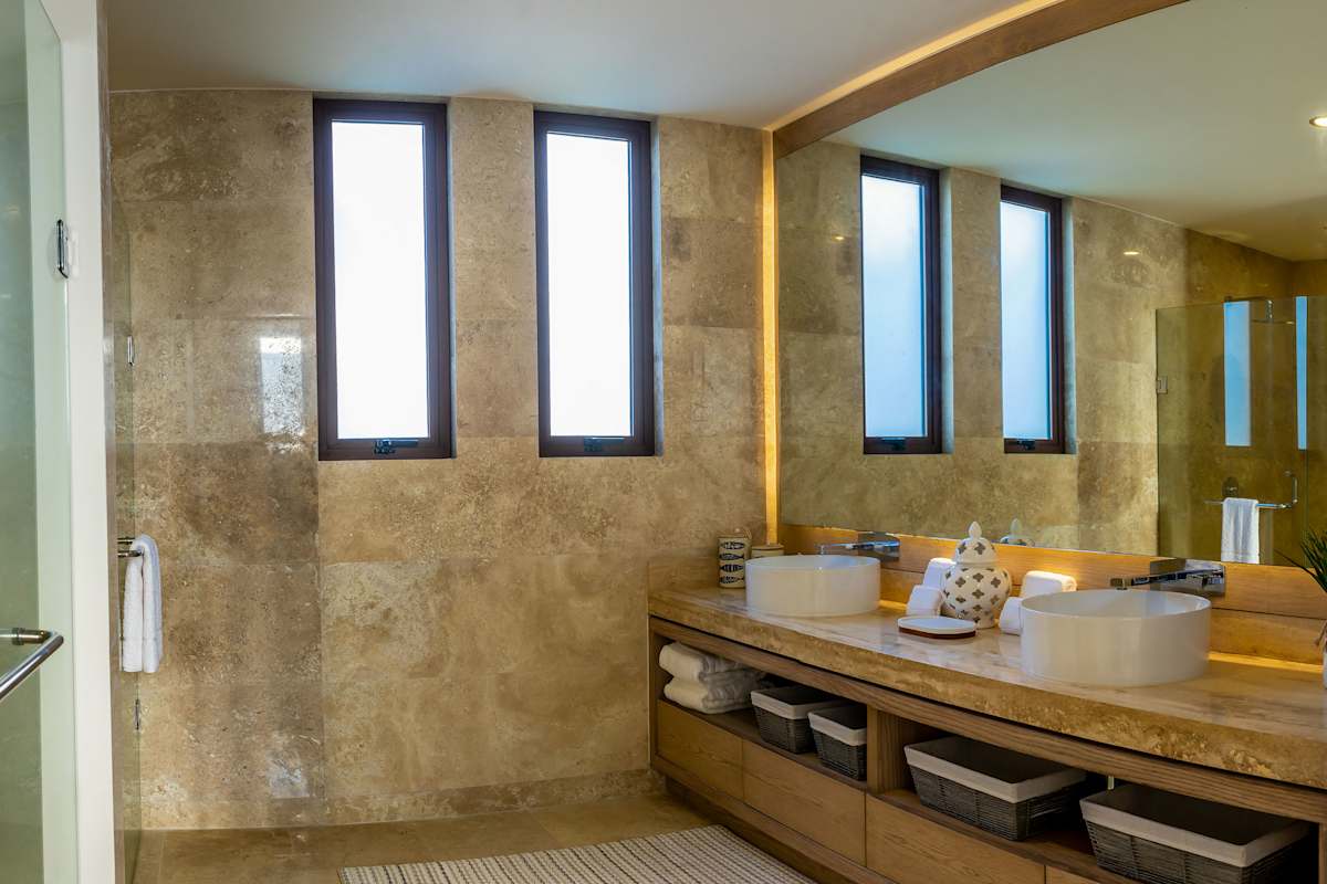 Full Bathroom 6 with a stone-surround double vanity, bright natural light, and upscale fixtures
