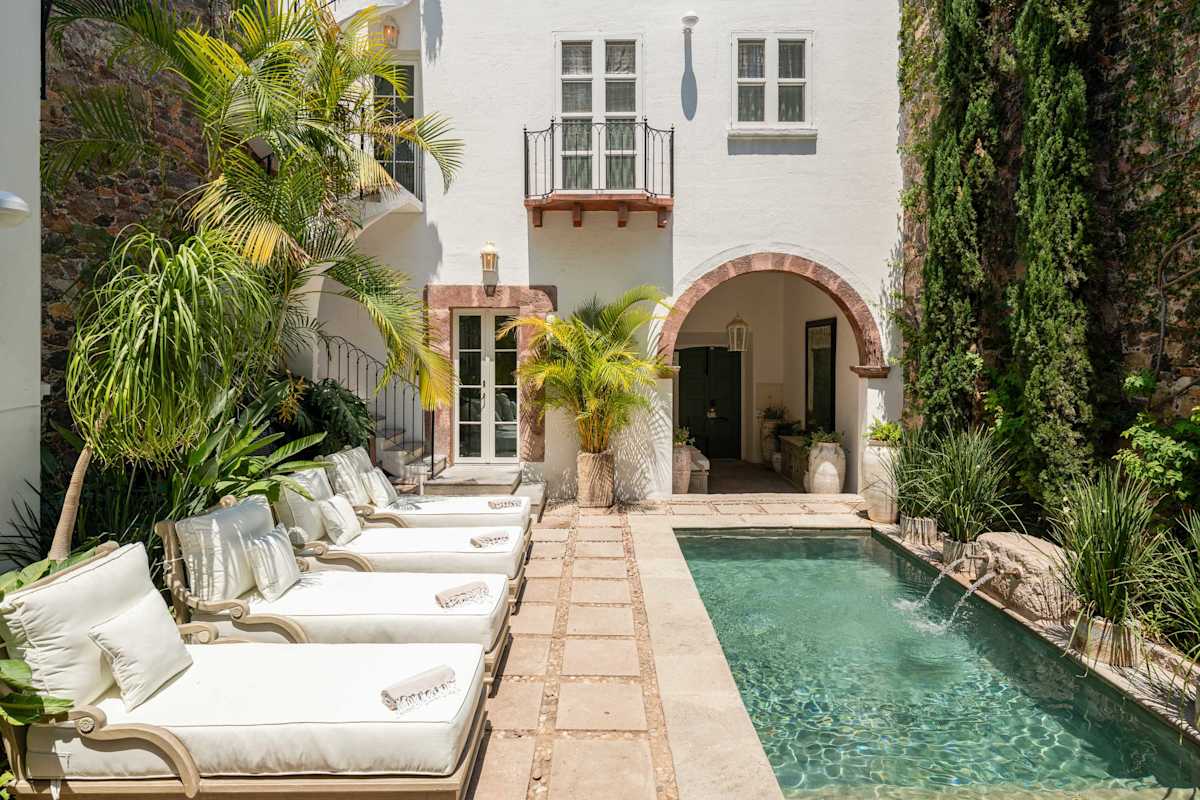 Poolside lounge chairs surrounded by lush greenery