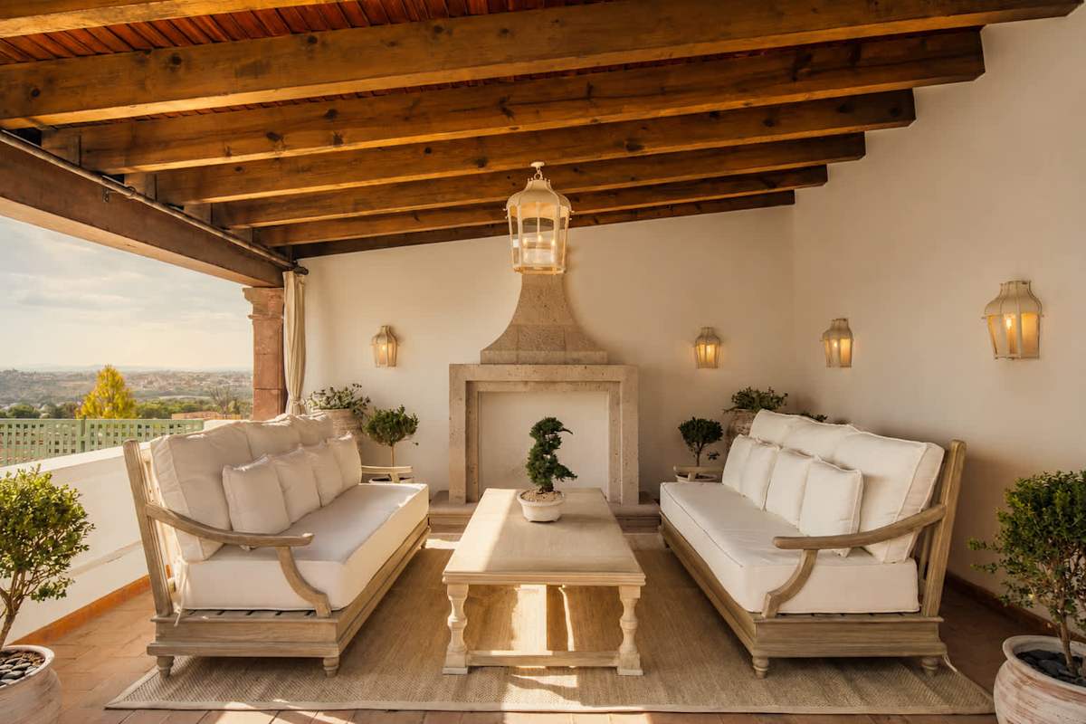 Rooftop lounge with outdoor fireplace and beamed ceiling