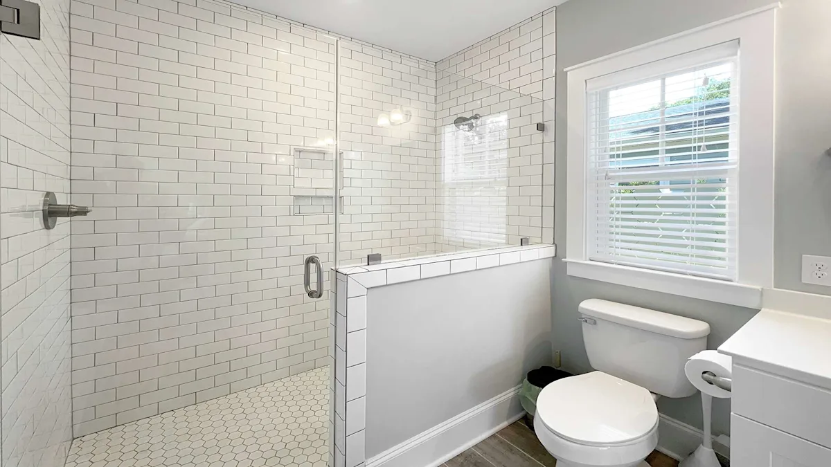 A clean bathroom with white tiles, a shower, bathtub, toilet, and window.