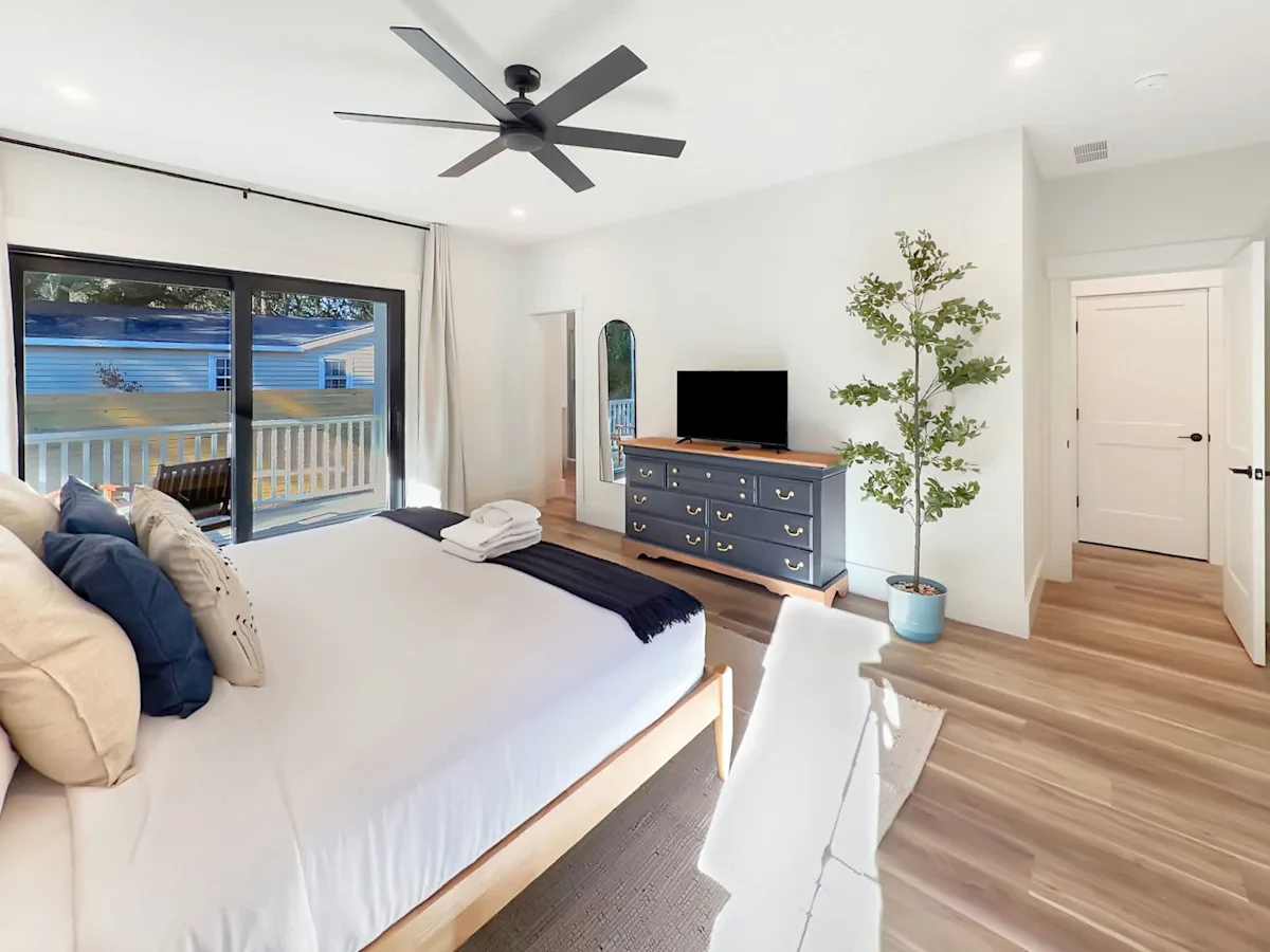 A bright and airy hotel room with a large bed, TV, and window