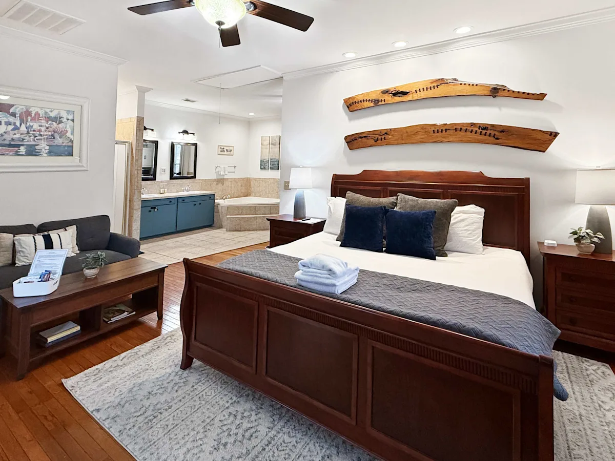 A large suite with a king-size bed, sofa, and jacuzzi in the bathroom