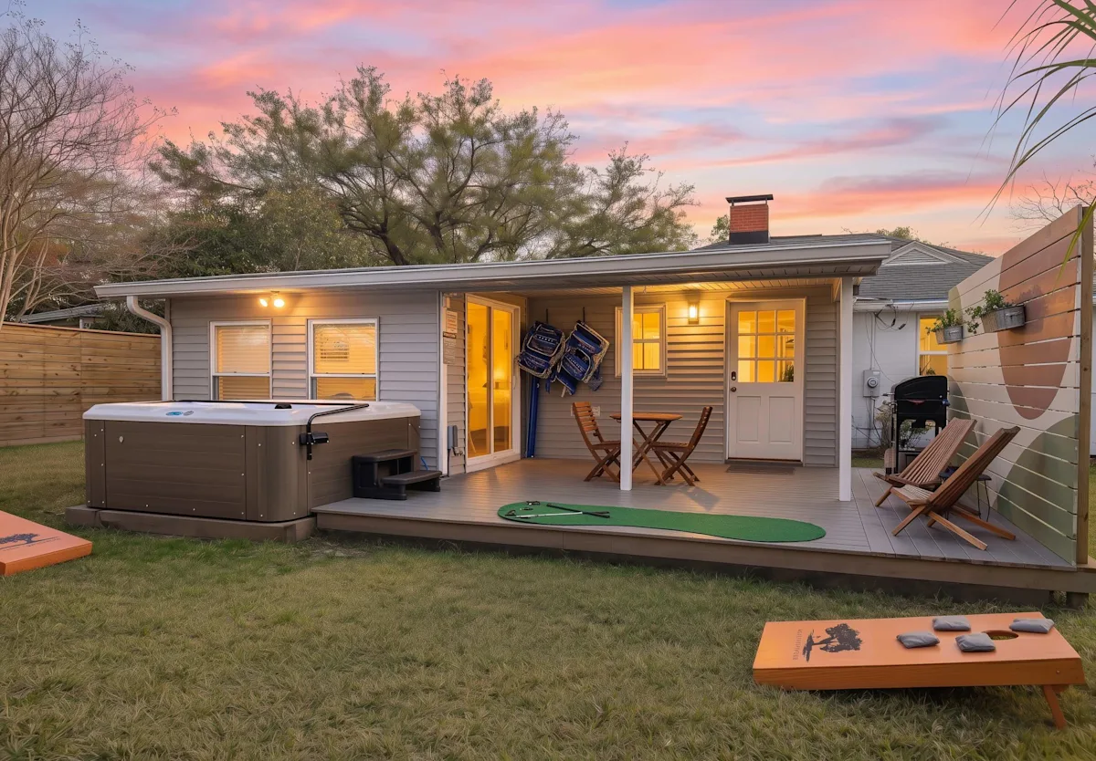 A house with a deck, hot tub, and outdoor furniture during sunset