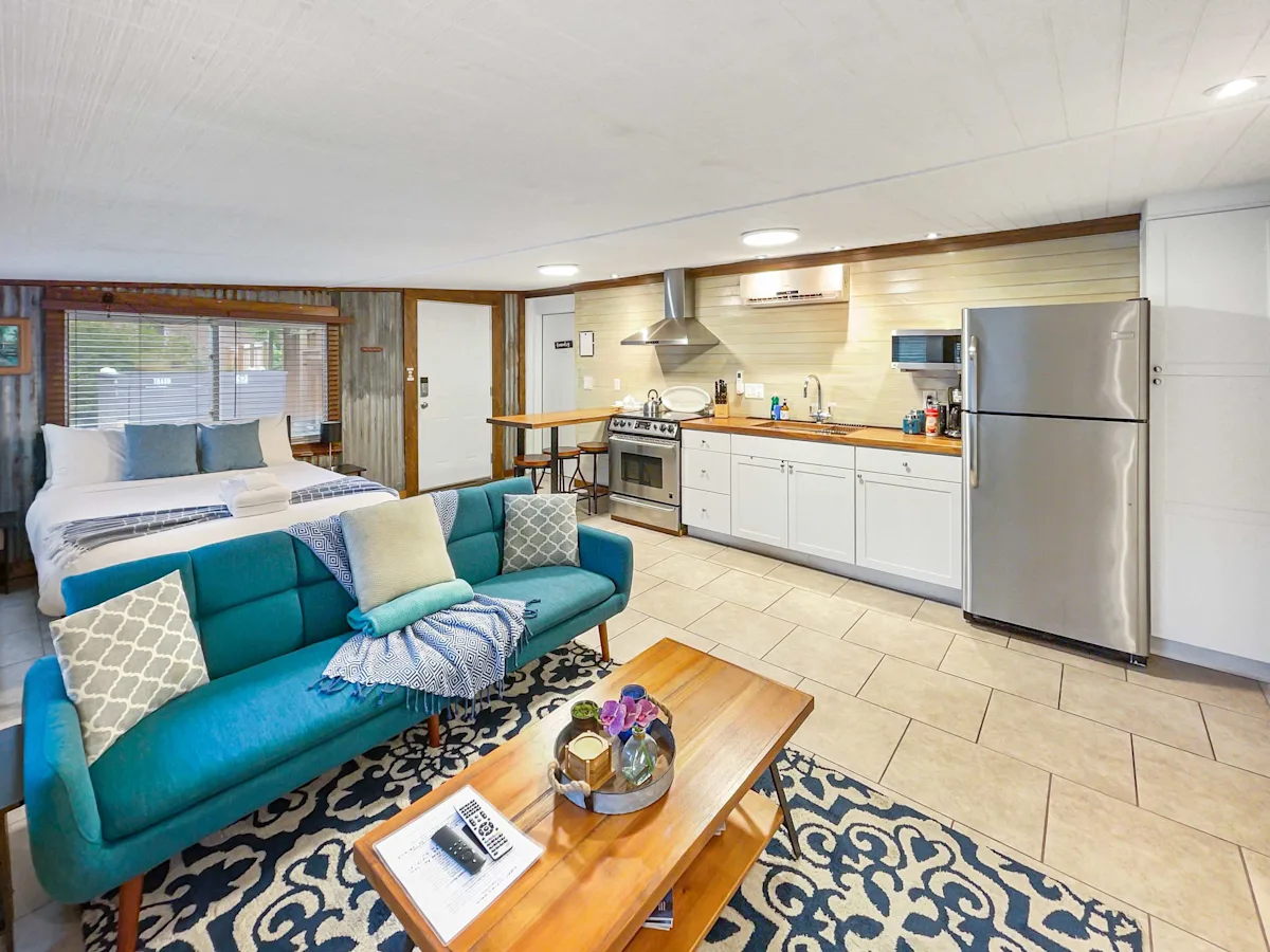 A spacious suite with a sofa, coffee table, kitchenette, refrigerator, and bed
