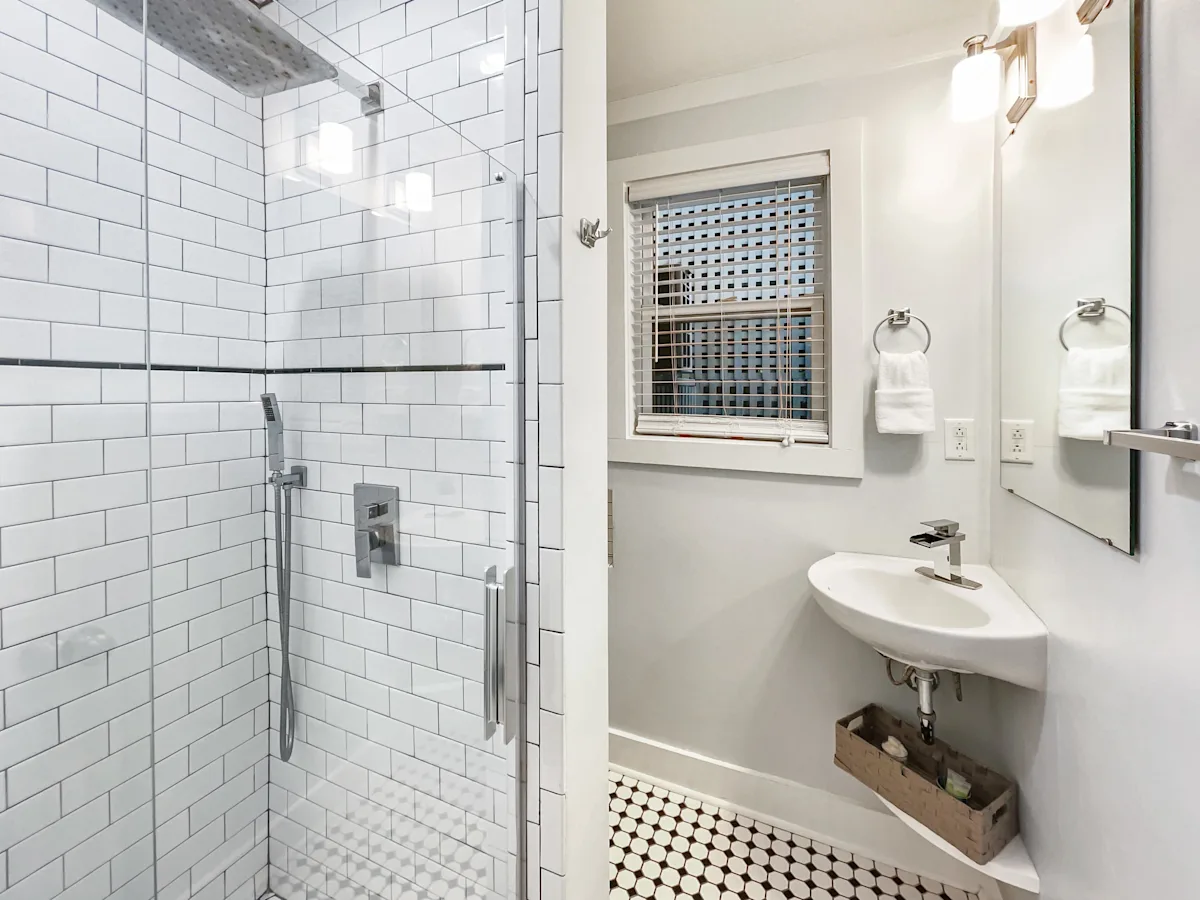 A clean bathroom with a shower, sink, and mirror