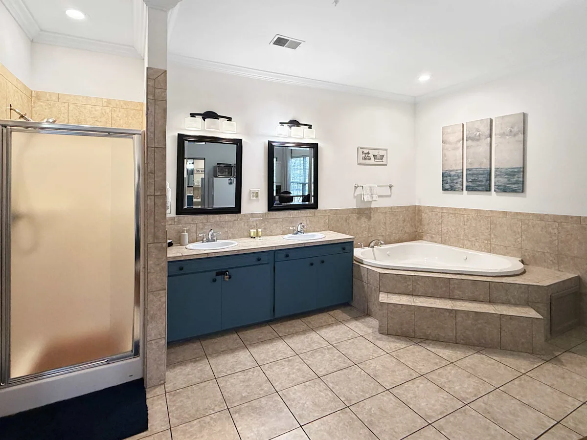 A large bathroom with a double vanity, jacuzzi tub, and shower.