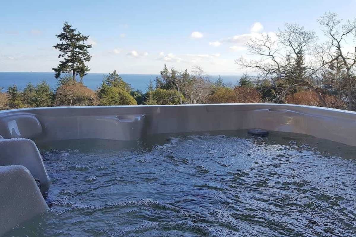 Hot tub overlooks the Juan de Fuca Strait and Olympic Mountains.