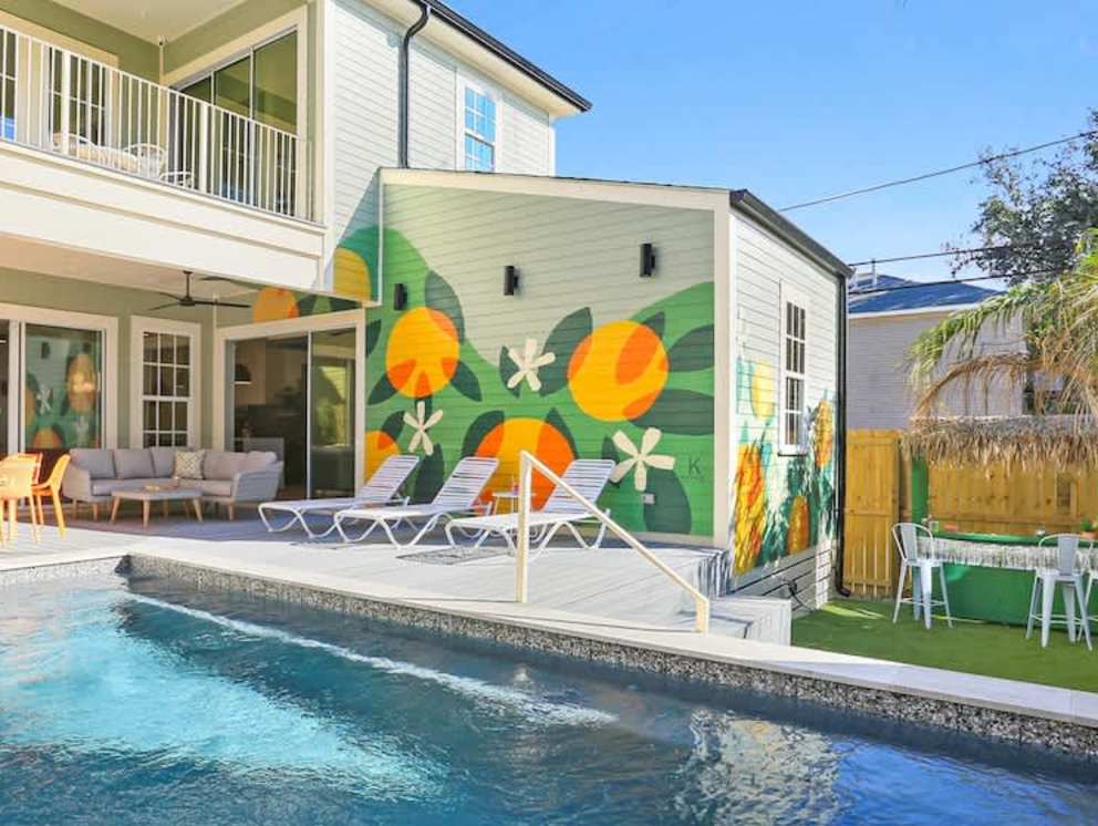 A mural of satsumas, blossoms and leaves filling the wall beside the pool