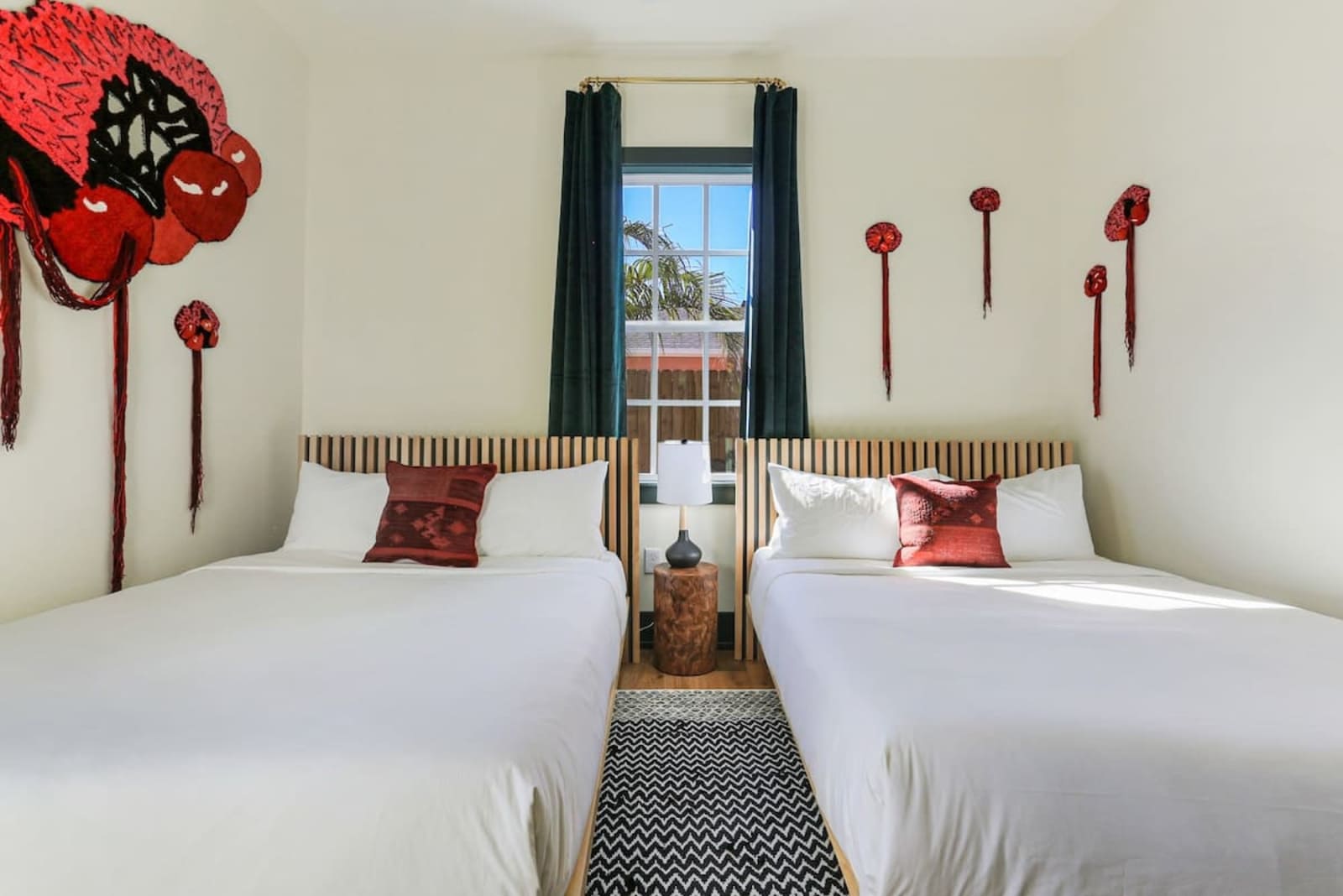 Red blossom sculptures mounted on the wall above two beds