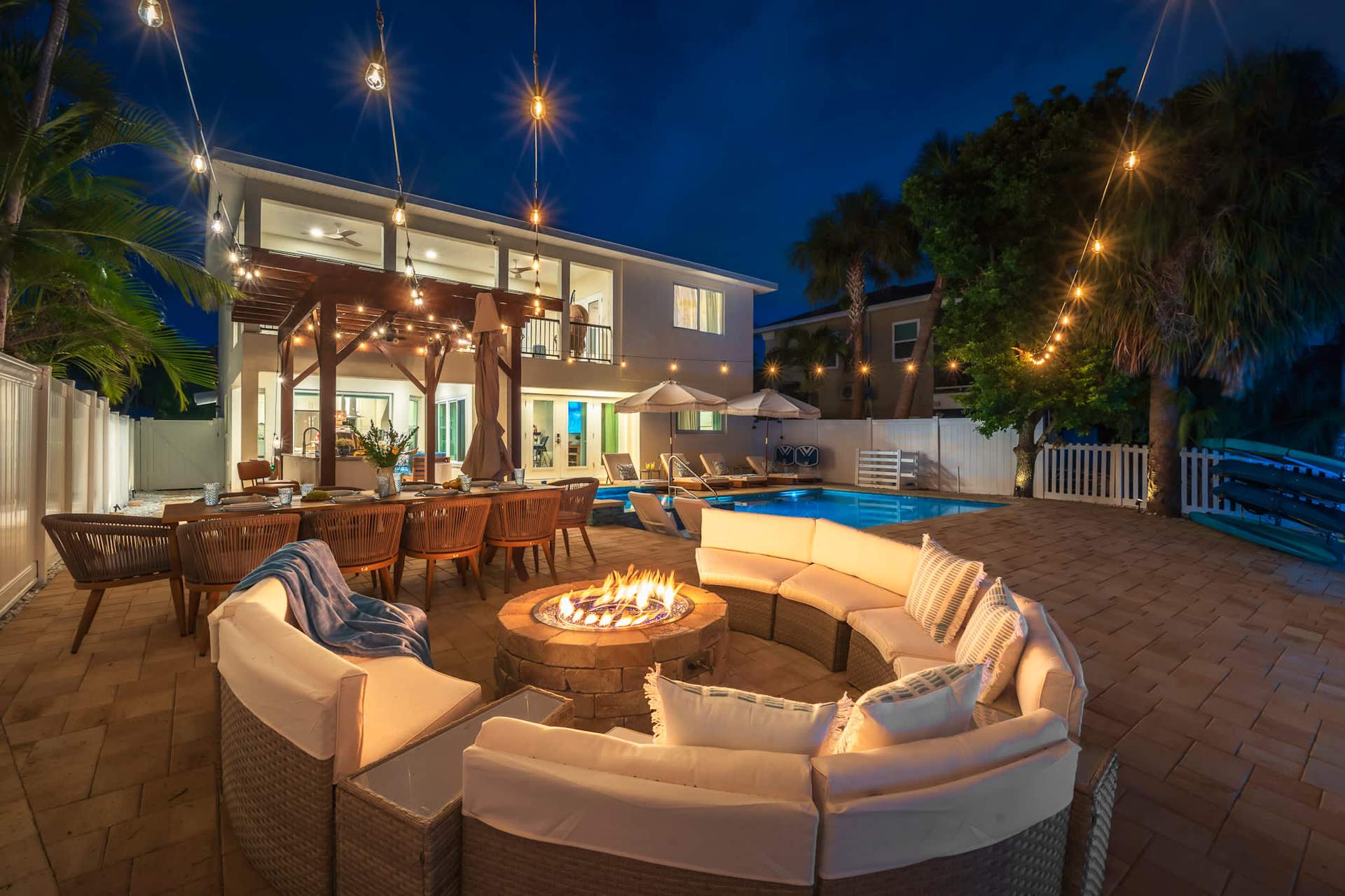 Patio with fire pit and string lights at dusk