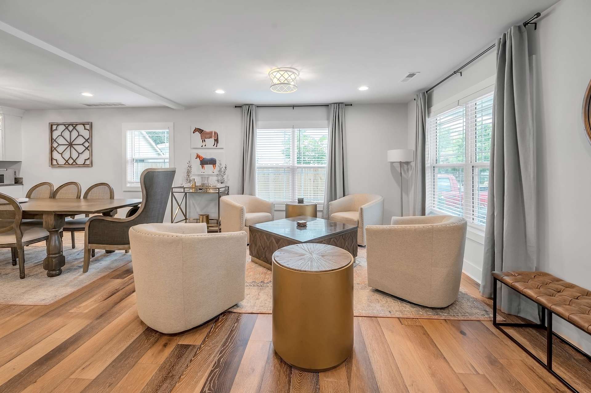 Walk in and take the whole layout in at once — open staircase, full kitchen, dining table, and a swivel-chair lounge nook, all in one sightline for a group that doesn't want to split up.