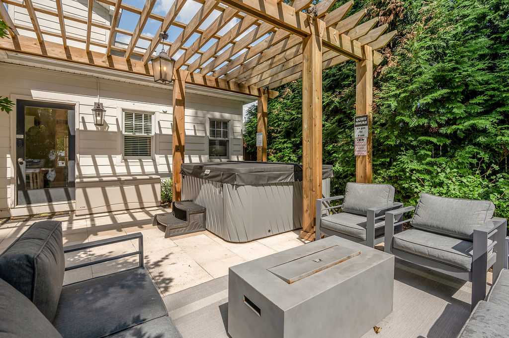 Private hot tub, fire-pit table and grill under the pergola — your most-praised feature.