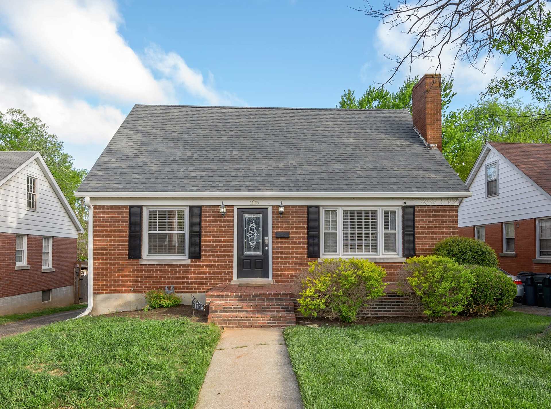Classic brick home with great curb appeal — spacious driveway with room for the whole group to park up and settle in.