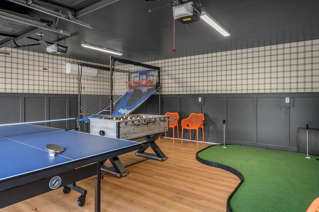Game room with ping pong, pop-a-shot basketball, foosball and an indoor putting green.