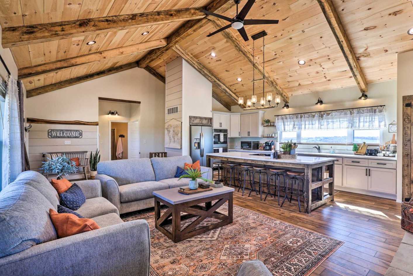 Walk in and you'll see the whole group fits in one room — cook at the island, sprawl on the sectional, and look up at ceilings that never quit. This is home base for the next few days.
