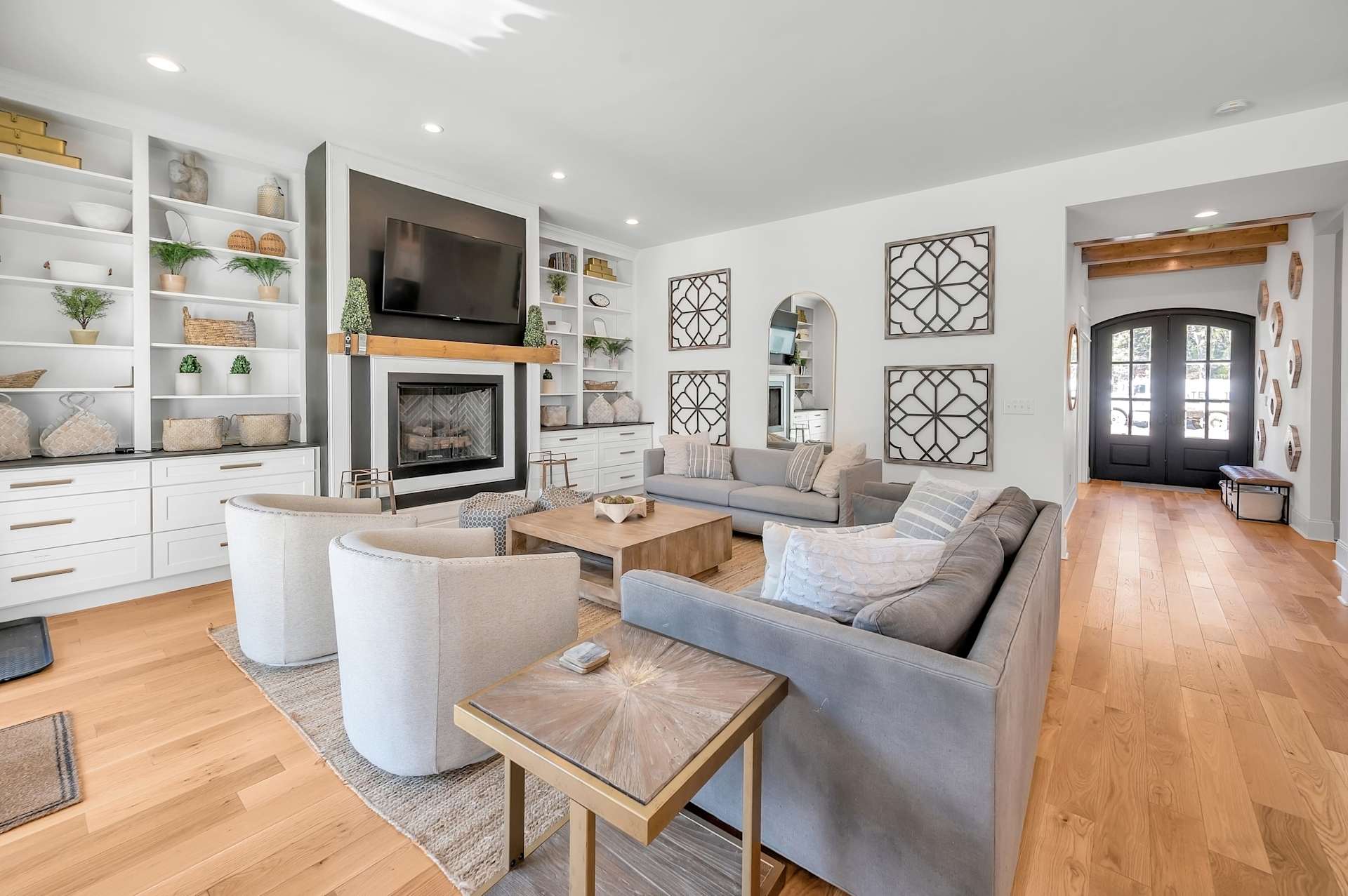 Everyone finds their spot here — built-in shelving, gas fireplace, spacious sectional, and French doors to the backyard. The main gathering room earns the name.
