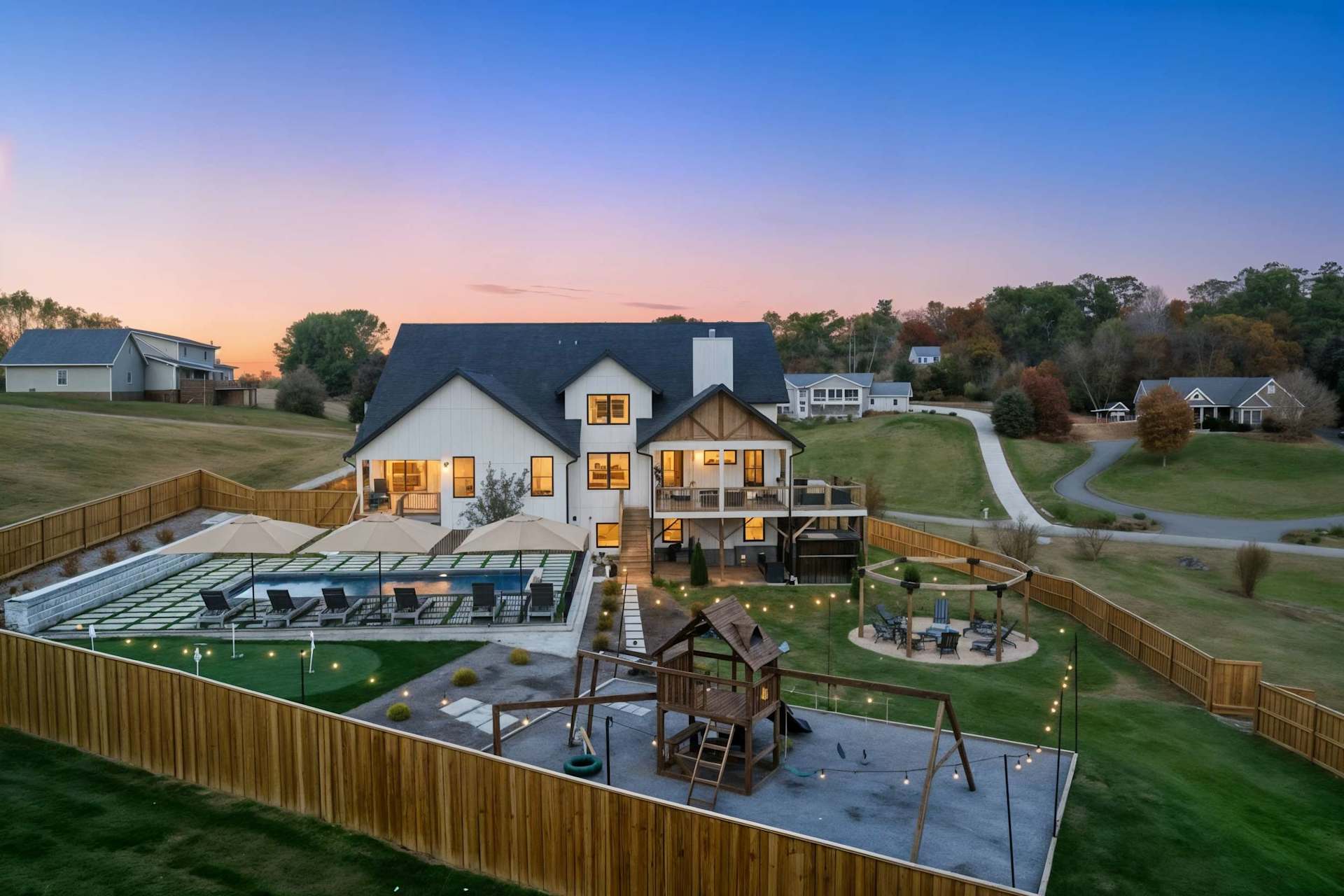 Pull up to the whole estate glowing at dusk — pool lit, fire pit waiting, mountains behind. The moment your group realizes this weekend is going to be unforgettable.