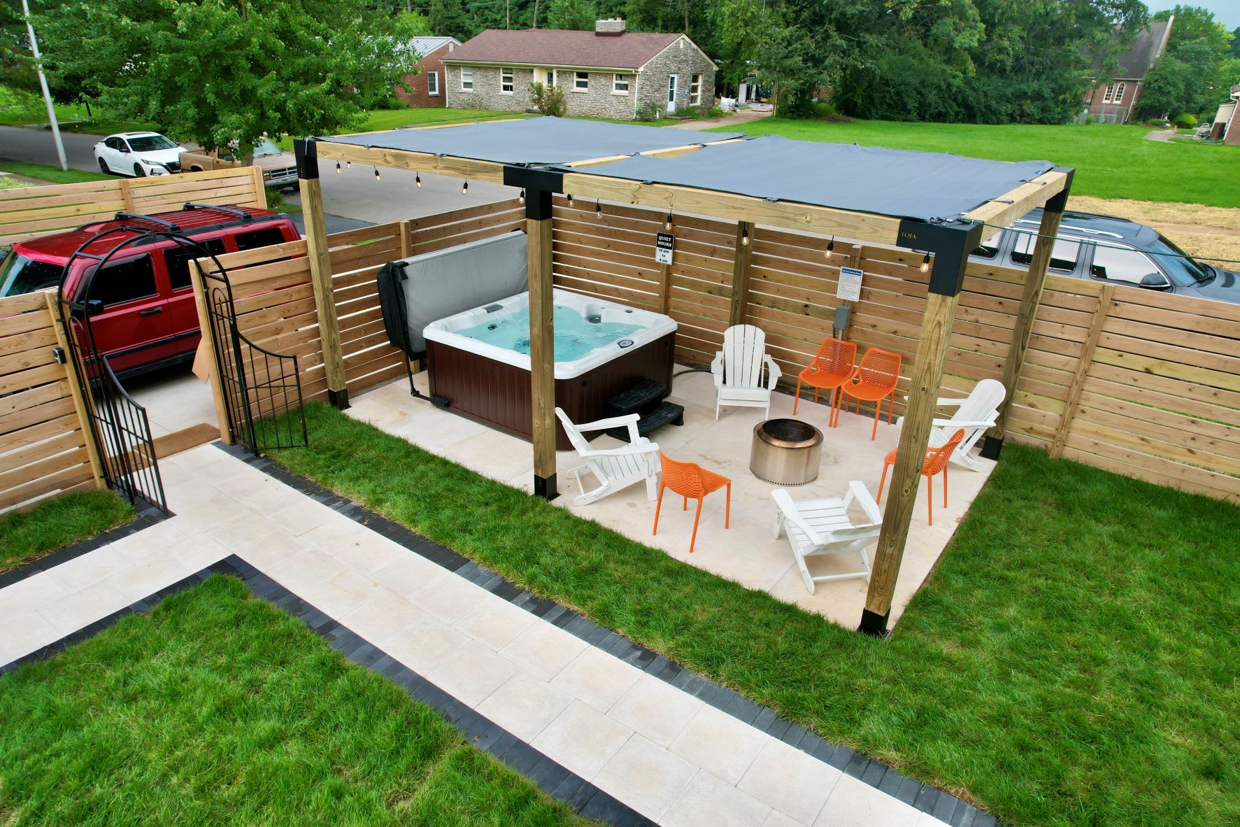 Slip into the private hot tub after dark — fire pit glowing, Adirondack chairs waiting, fenced yard all yours. This is the shot guests keep mentioning in their five-star reviews.