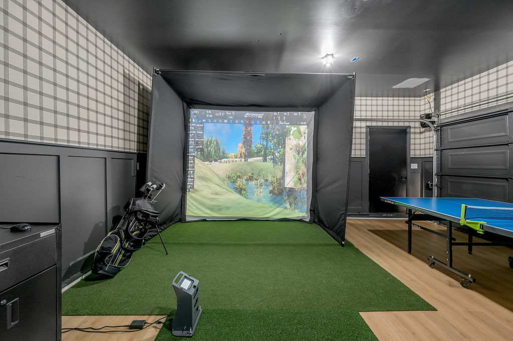 Step up to the tee and drive a full round without ever leaving the house — your own golf simulator bay is ready when you are.
