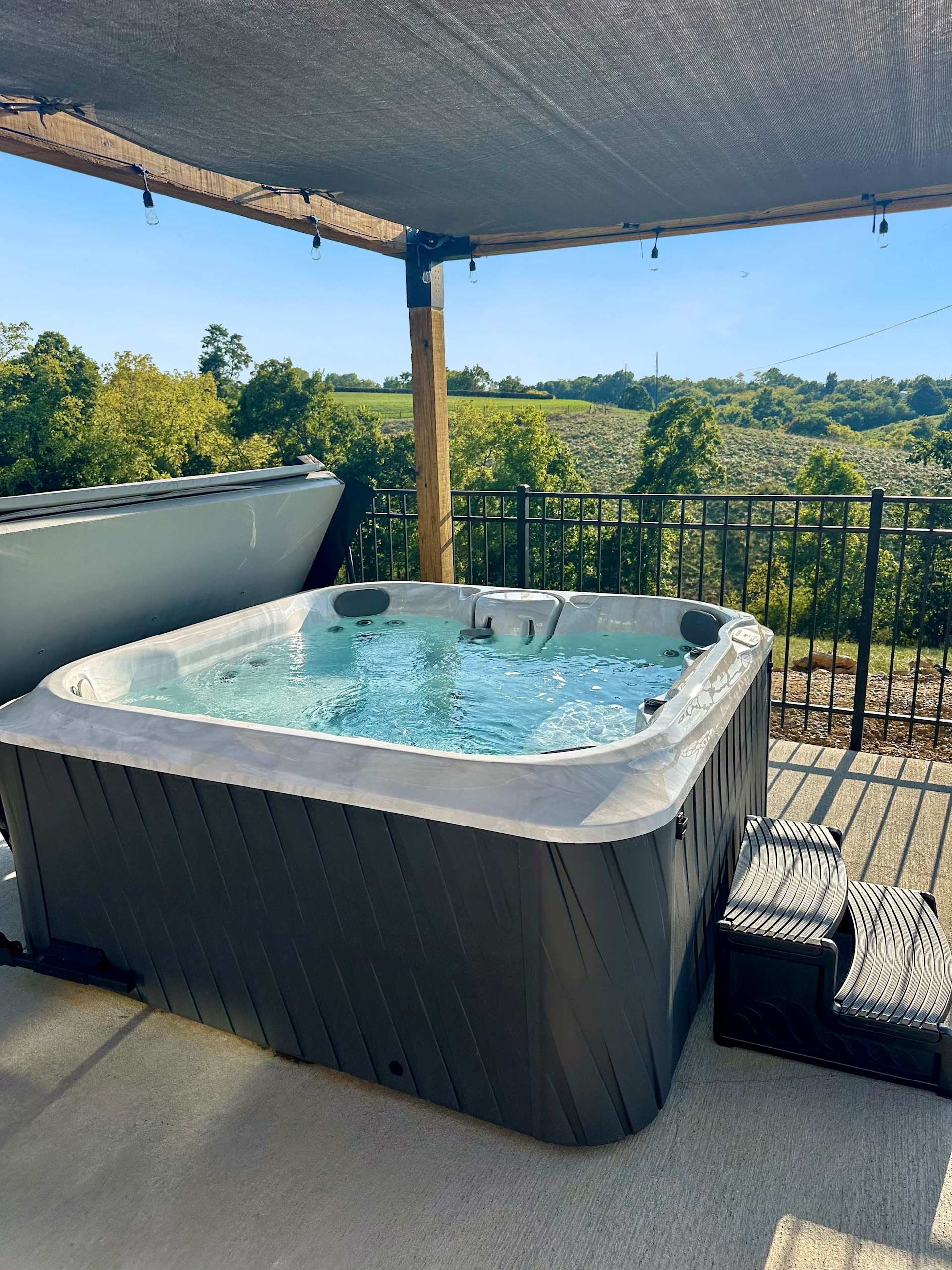 Slide in at sunset, hills rolling out in every direction. The hot tub runs year-round — this view is just a bonus.