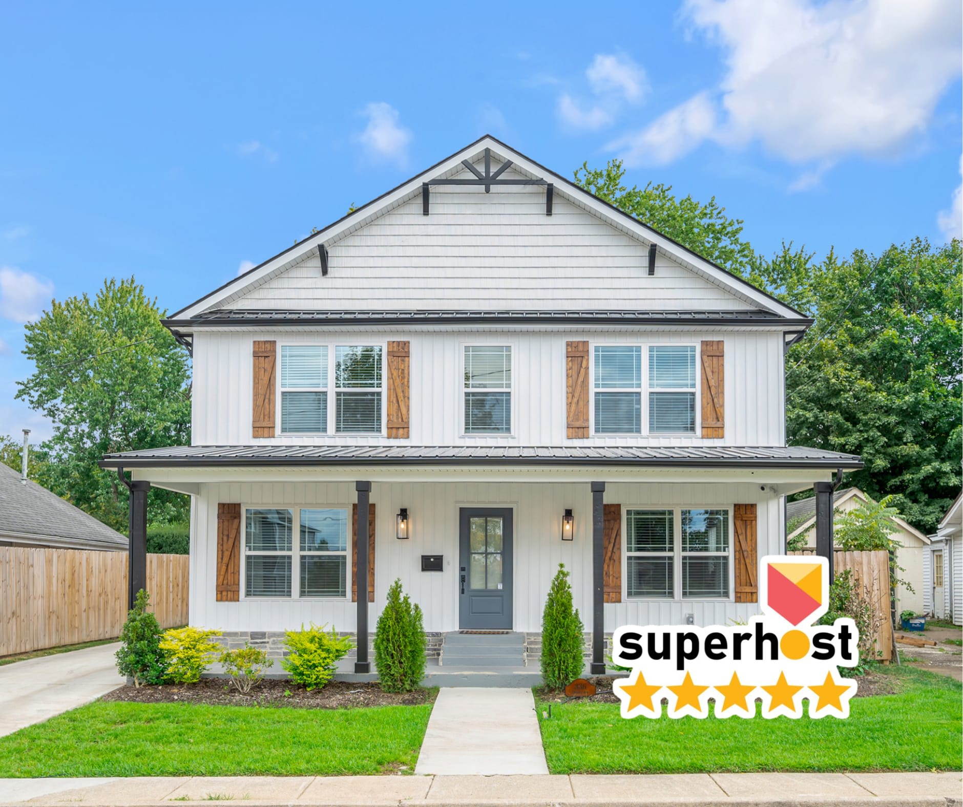 Pull in and feel the trip start — a crisp white farmhouse, a covered porch wide enough to greet the whole group, and fencing on both sides so the kids can run loose from minute one.