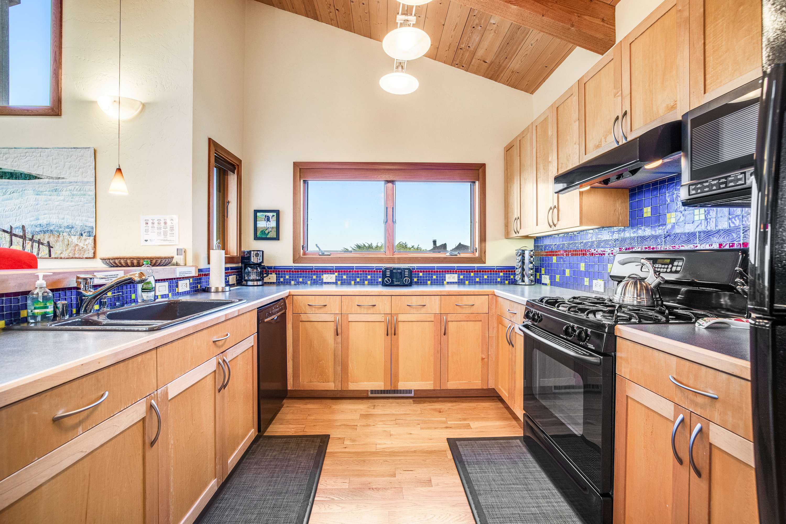 Cook up a storm in the well-equipped kitchen, featuring vibrant tiles that inspire culinary creativity amidst beautiful surroundings.