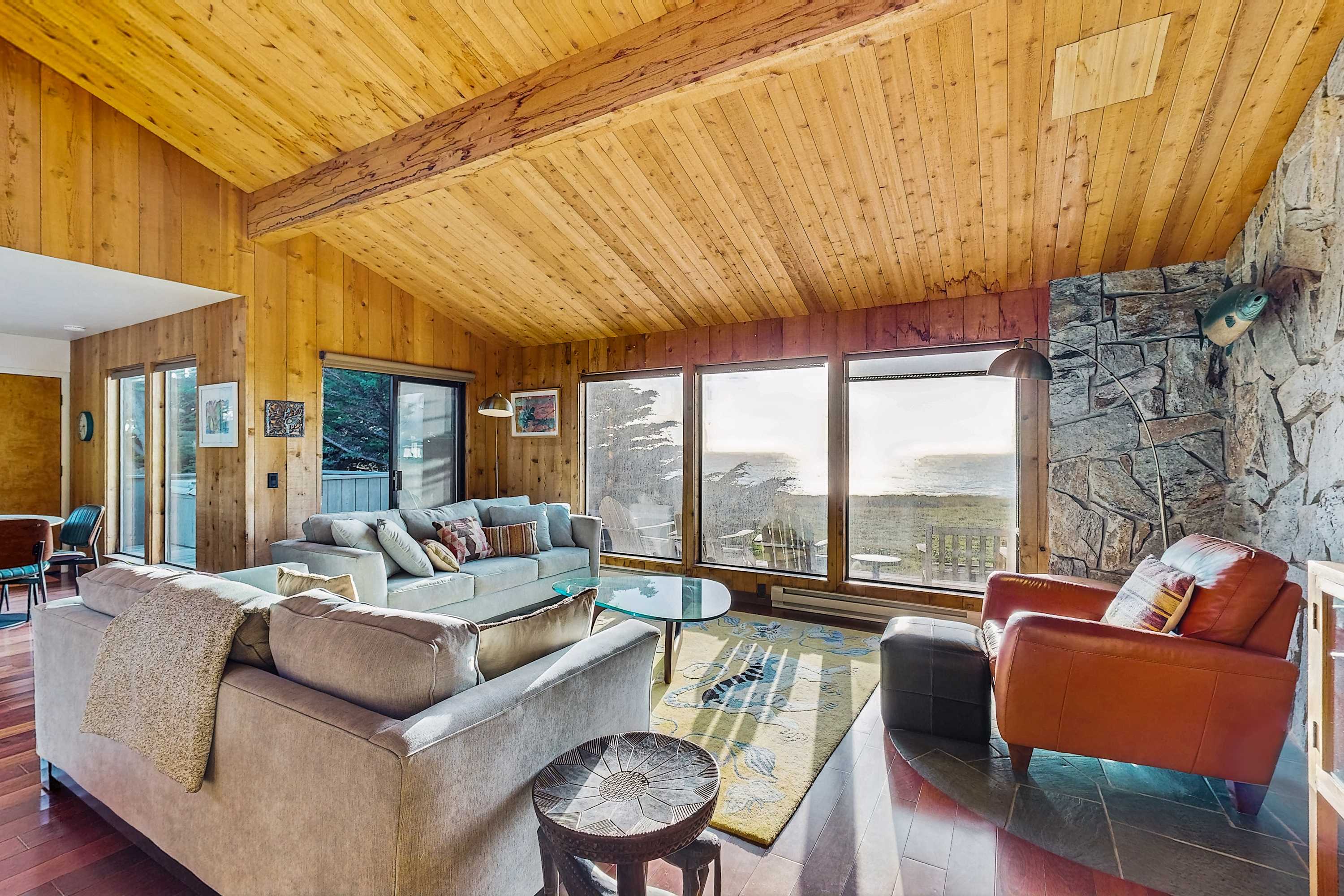 Bask in the warmth of natural wood and stunning ocean views as you relax in the inviting living room, perfect for unwinding after a day of coastal adventures.