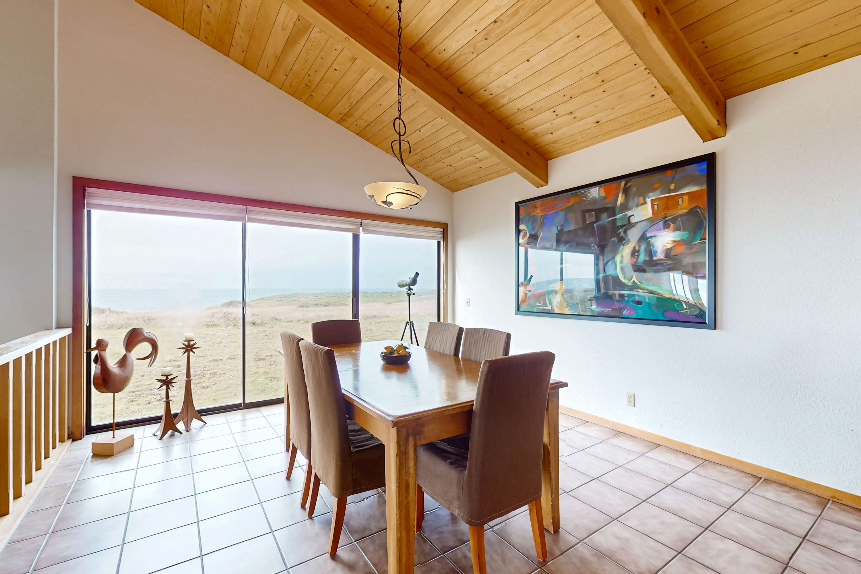 Enjoy meals with a view in this charming dining area, where sunlight dances off the table and the ocean beckons just beyond.