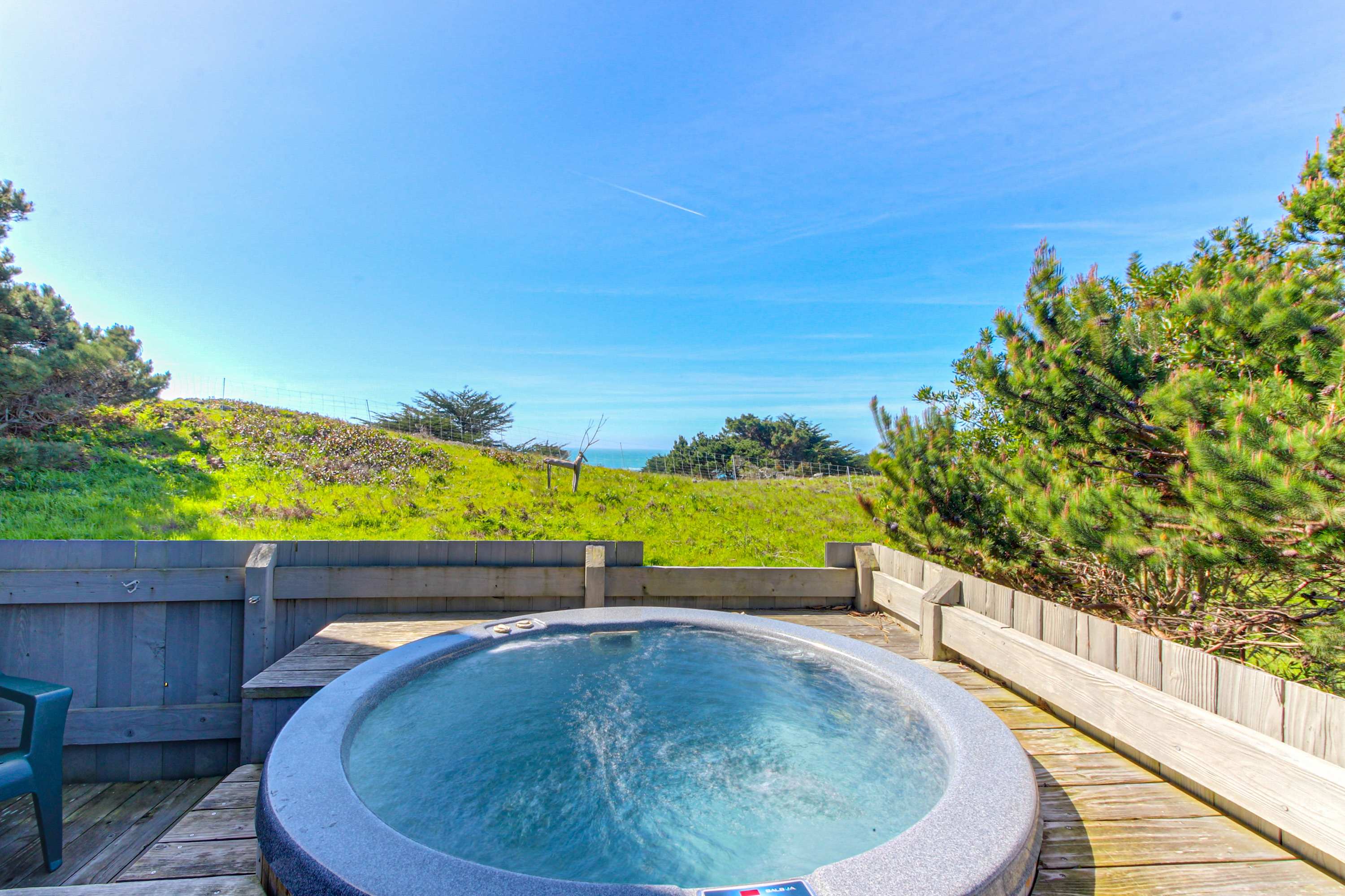 Soak in the private hot tub with stunning ocean views, the perfect spot for relaxation after a day of exploration.