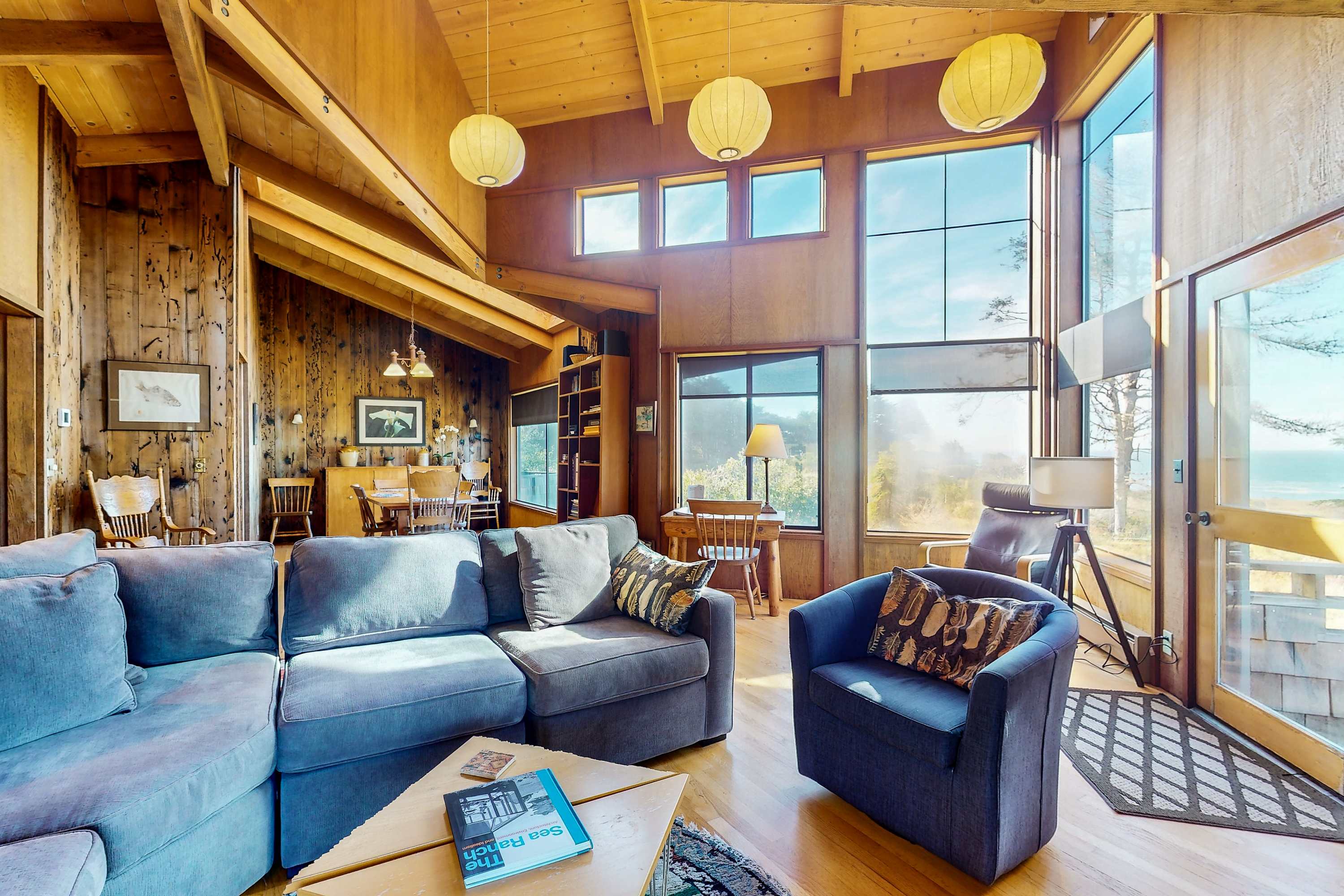Natural light floods the living room, highlighting stunning ocean views and creating an inviting space for family gatherings.