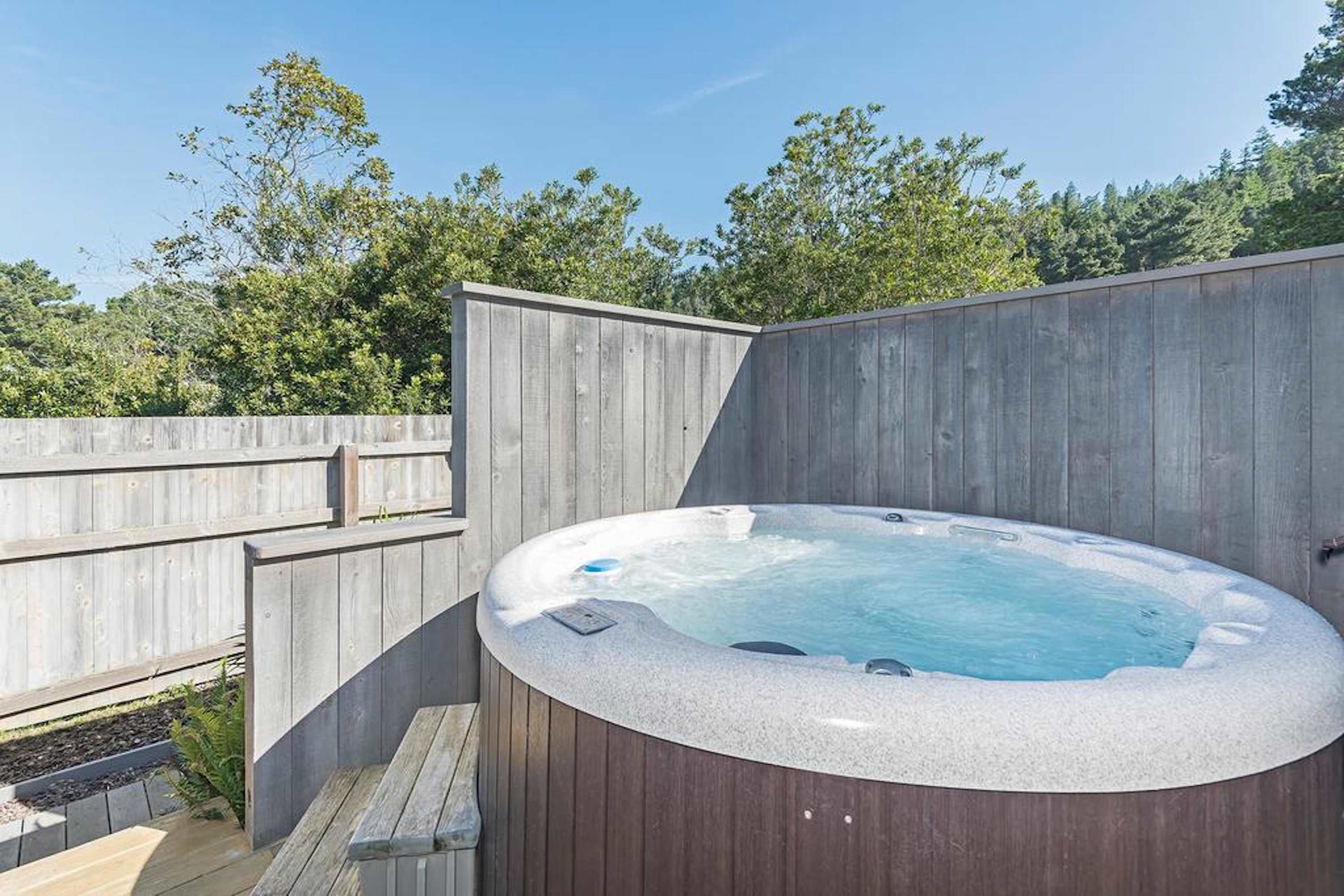 Soak under the stars in your private hot tub, a perfect retreat after a day of coastal adventures.