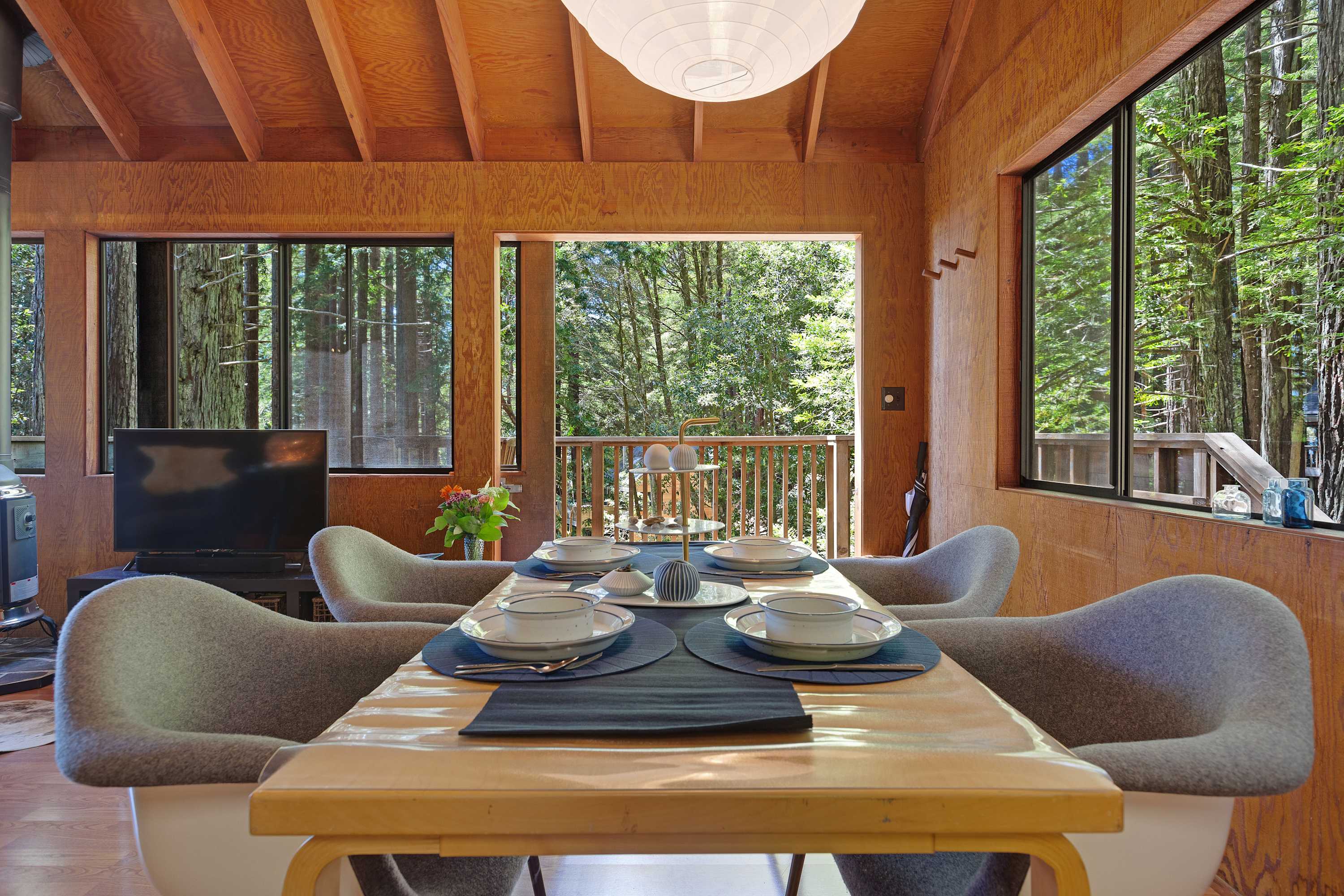 Set the scene for memorable meals in the dining area, where large windows frame the lush outdoors, making every gathering feel special.