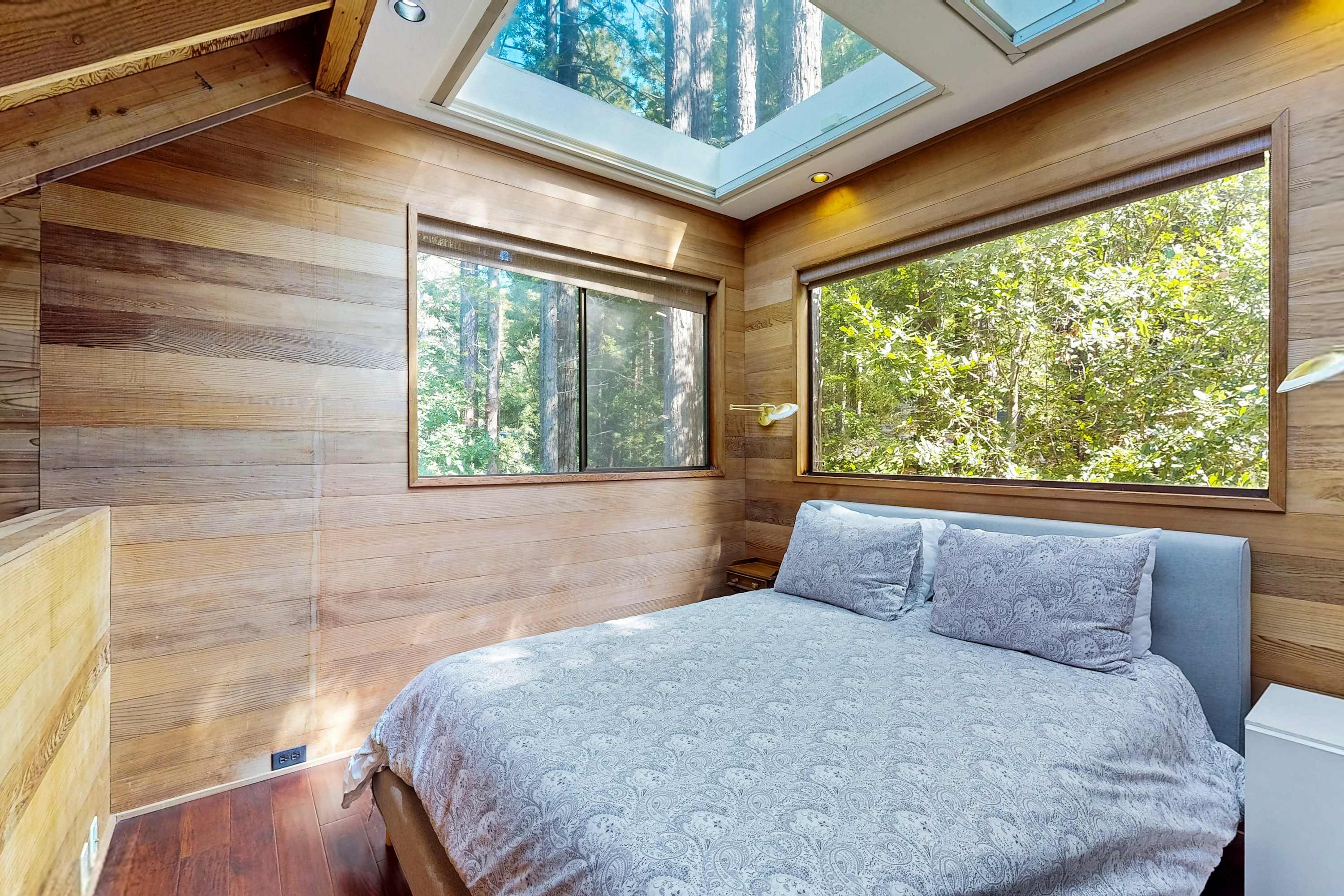Your peaceful retreat awaits in this tranquil bedroom, where natural light pours in through skylights, creating a serene atmosphere.
