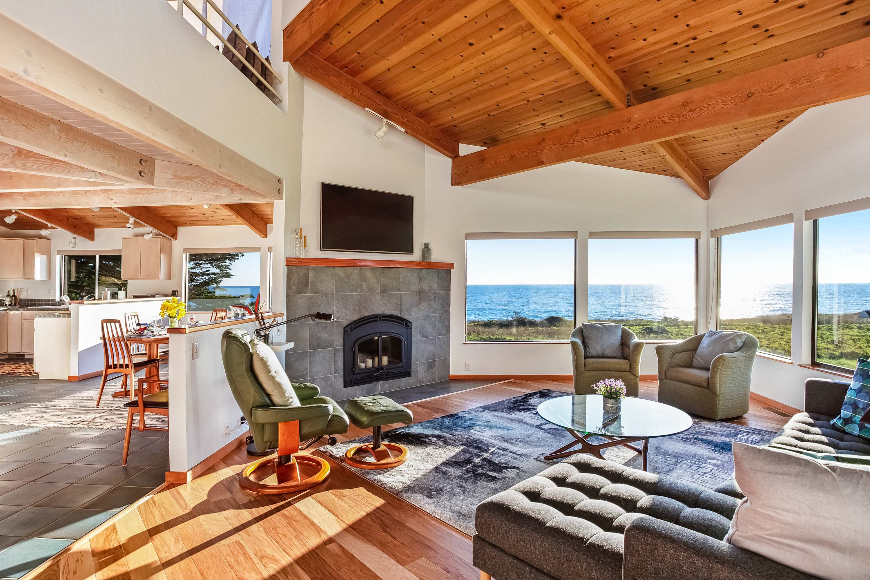 In the spacious living room, morning light dances across the ocean view, setting the perfect scene for cozy gatherings with loved ones.