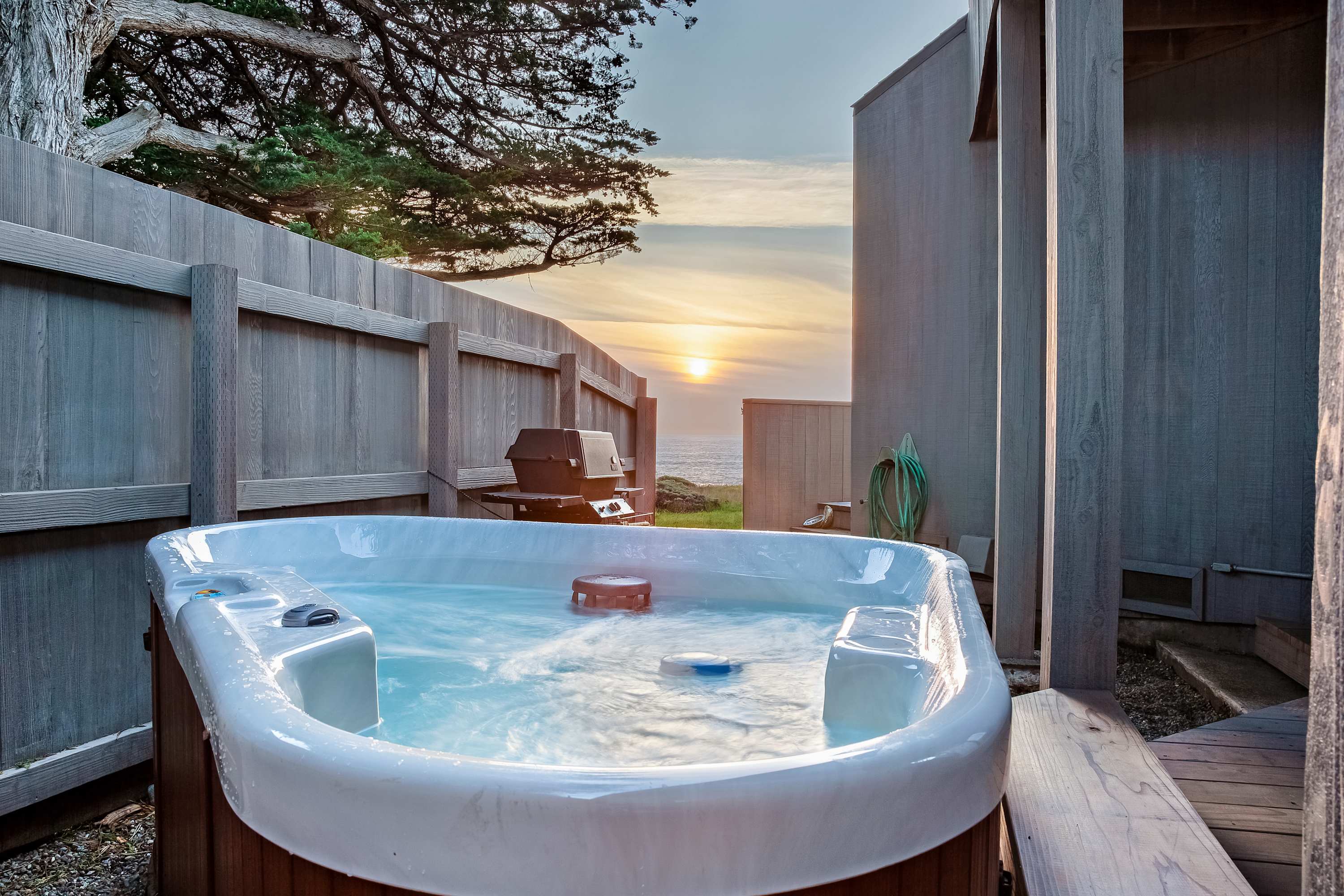 Imagine soaking in your private hot tub, sipping a drink while the sun dips below the ocean horizon, creating a perfect end to your day.