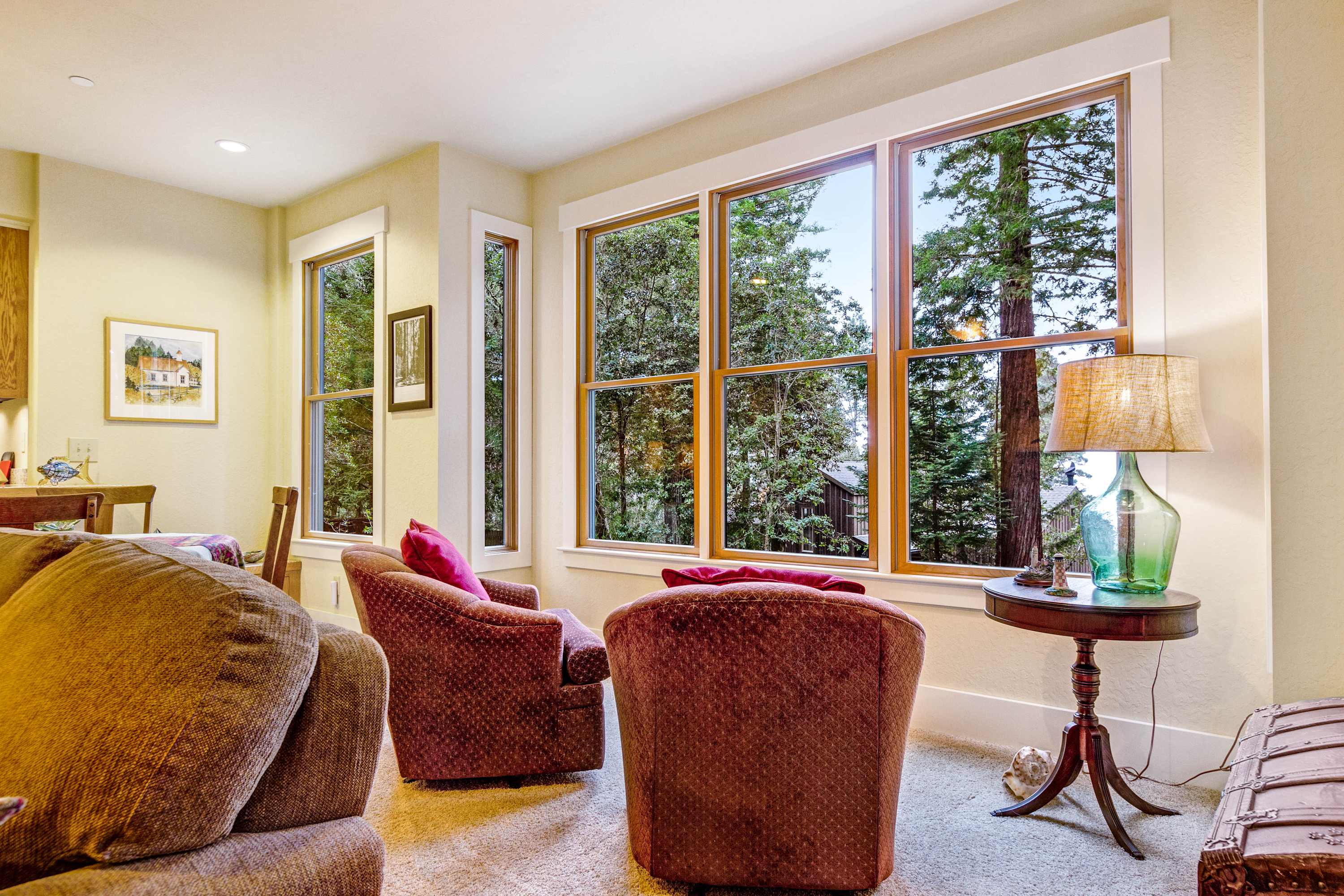 Sip your morning coffee in the sunlit corner of the living room, surrounded by views of lush trees.