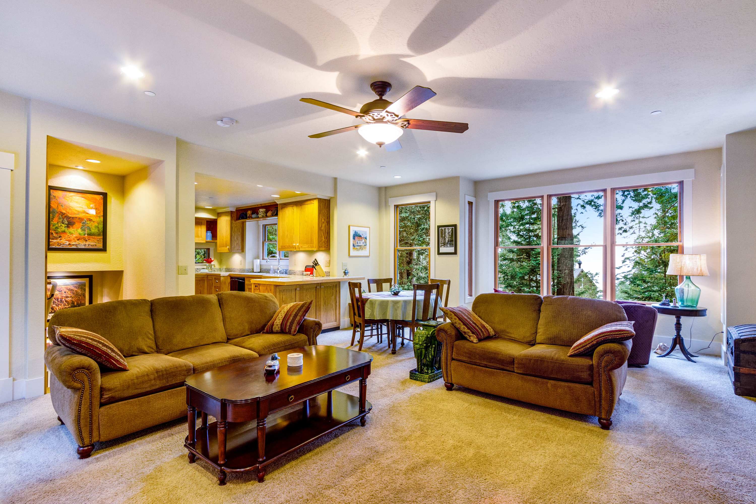 Picture yourself relaxing in the cozy living room, where large windows frame the vibrant greenery outside.