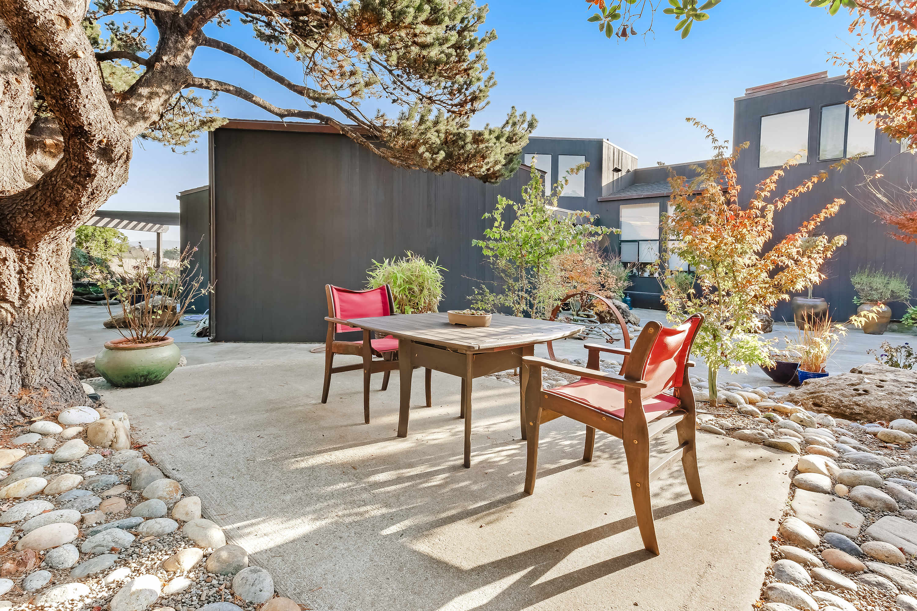 Imagine sipping your morning coffee surrounded by lush landscaping in this serene outdoor retreat.